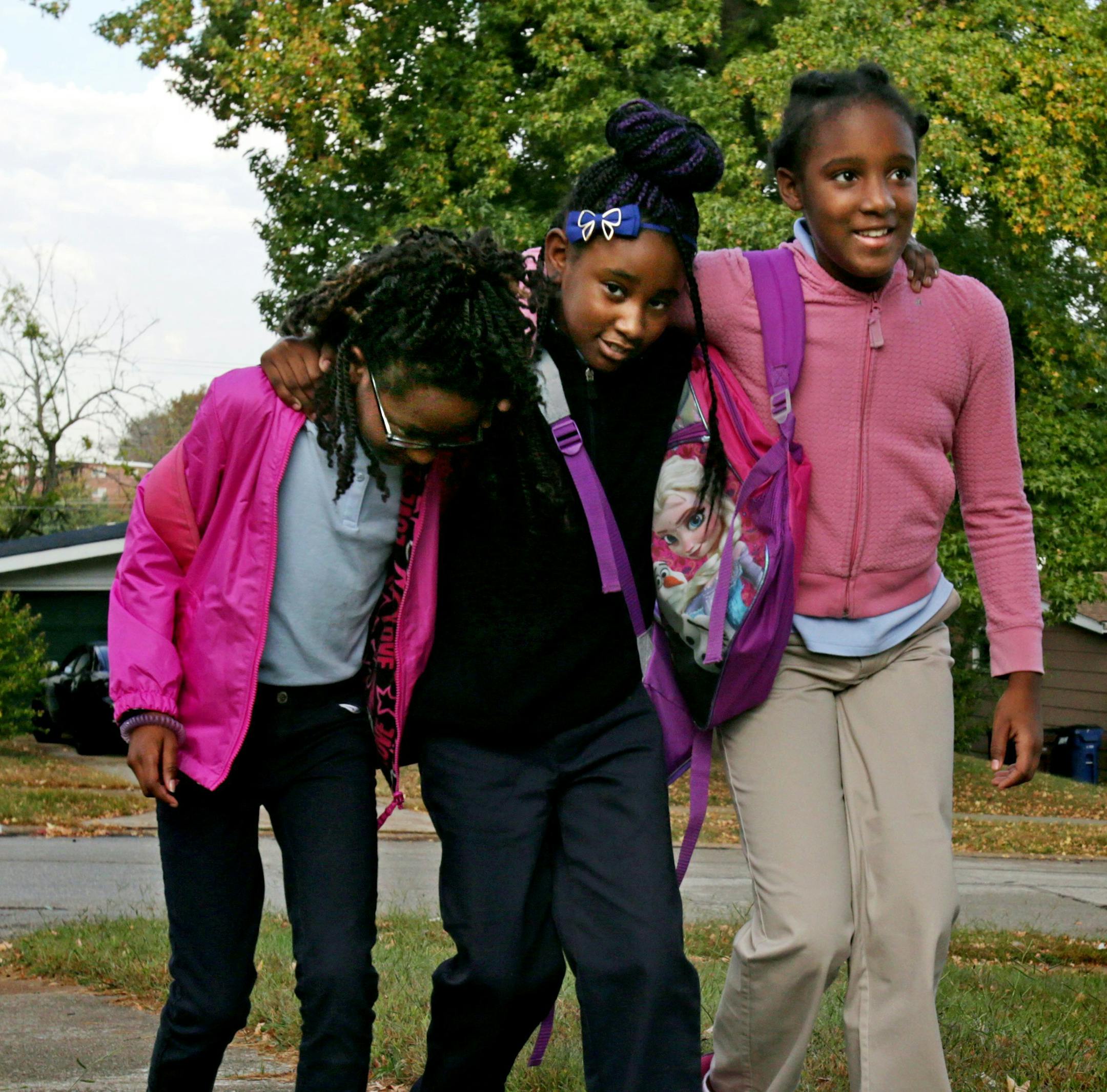 "It's a best friend thing. We always be holding on to each other," said Destiny Sommelier 10, (right), who walks with friends Saniya Bryant, 10, and best friend Akeeylah Kelly, 8, (center) near their bus stop on Wednesday, Oct. 21, 2015, in Ferguson, Mo. The girls often walk past the home deceased classmate Jamyla Bolden. (Laurie Skrivan/St. Louis Post-Dispatch/TNS)