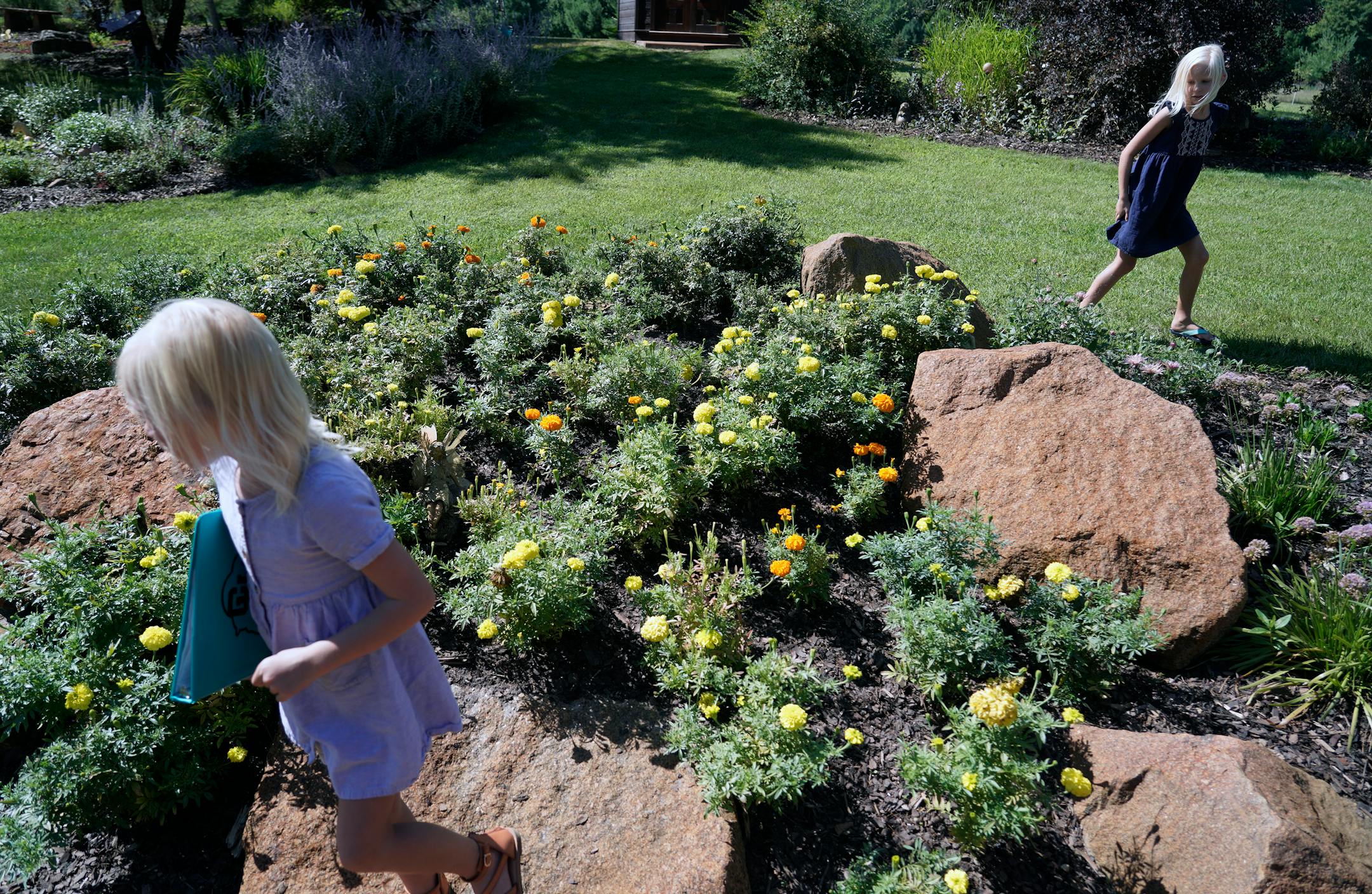 Beautiful Garden winner Coralee Fox has one goal for her Brainerd-area garden: to put a smile on the face of everyone who sees it. In this massive, four-acre plot, the 80-year-old, Crow Wing County master gardener pulls out all the stops. There's always something in bloom. Here, neighbors Hazel and Heidi Haarstad, ages 5 and 7, left and right, search for fairies in the garden. They have a book with stories about each one.
