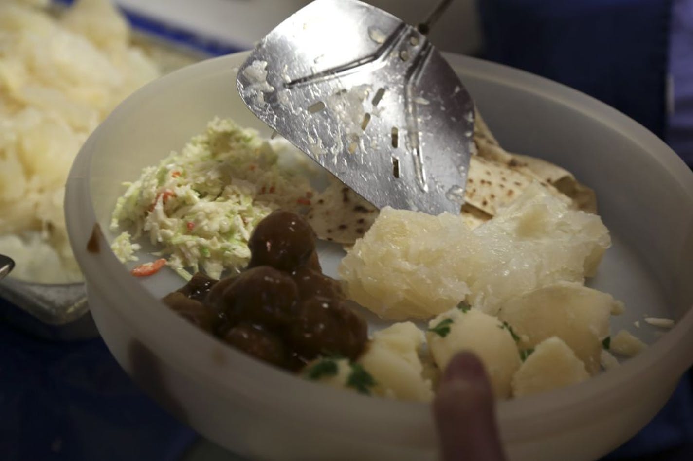 Natalie Hanson filled the remaining space in a take home container with lutefisk after the first of three lutefisk dinners at Mindekirken Church in Minneapolis, Min., Saturday November 17, 2012.