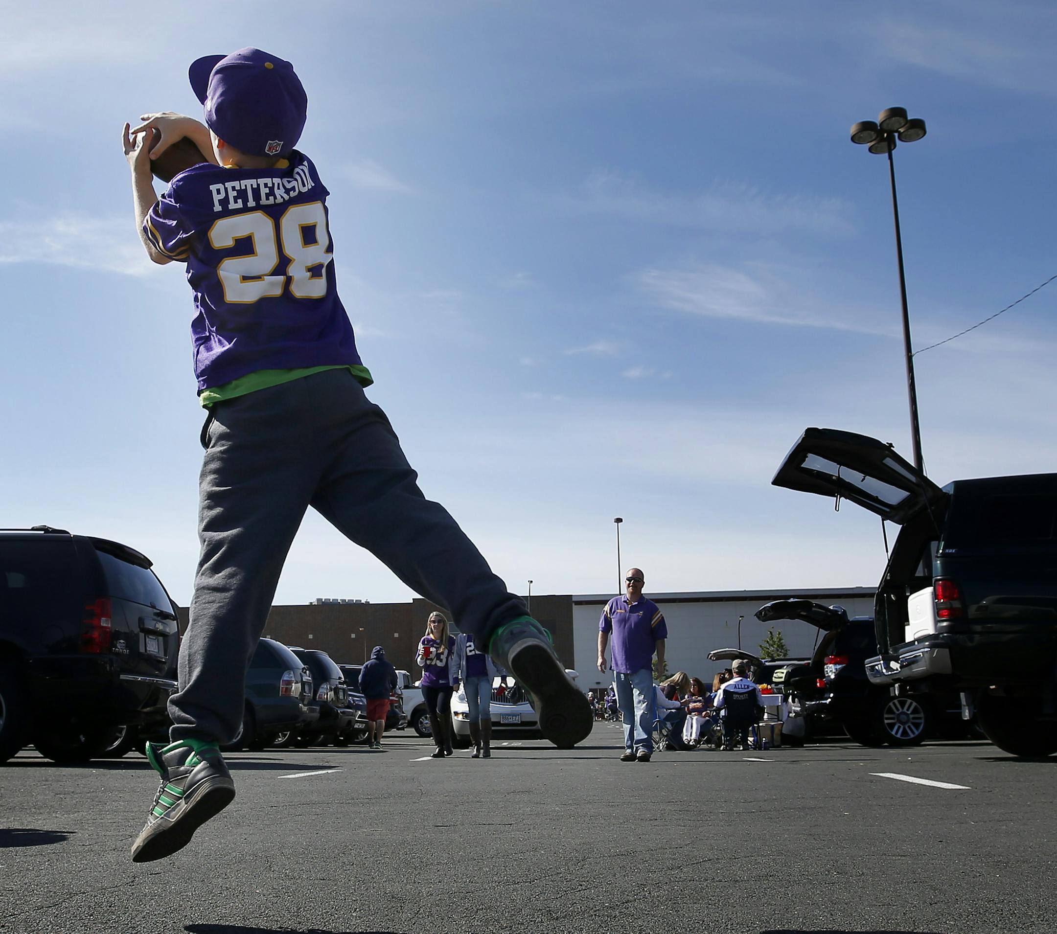 Wearing an Adrian Peterson jersey Ethan Trowbridge, 11, of Prior Lake played catch with his dad Jim before Sunday's game TCF Bank Stadium between the Minnesota Vikings vs. New England Patriots.