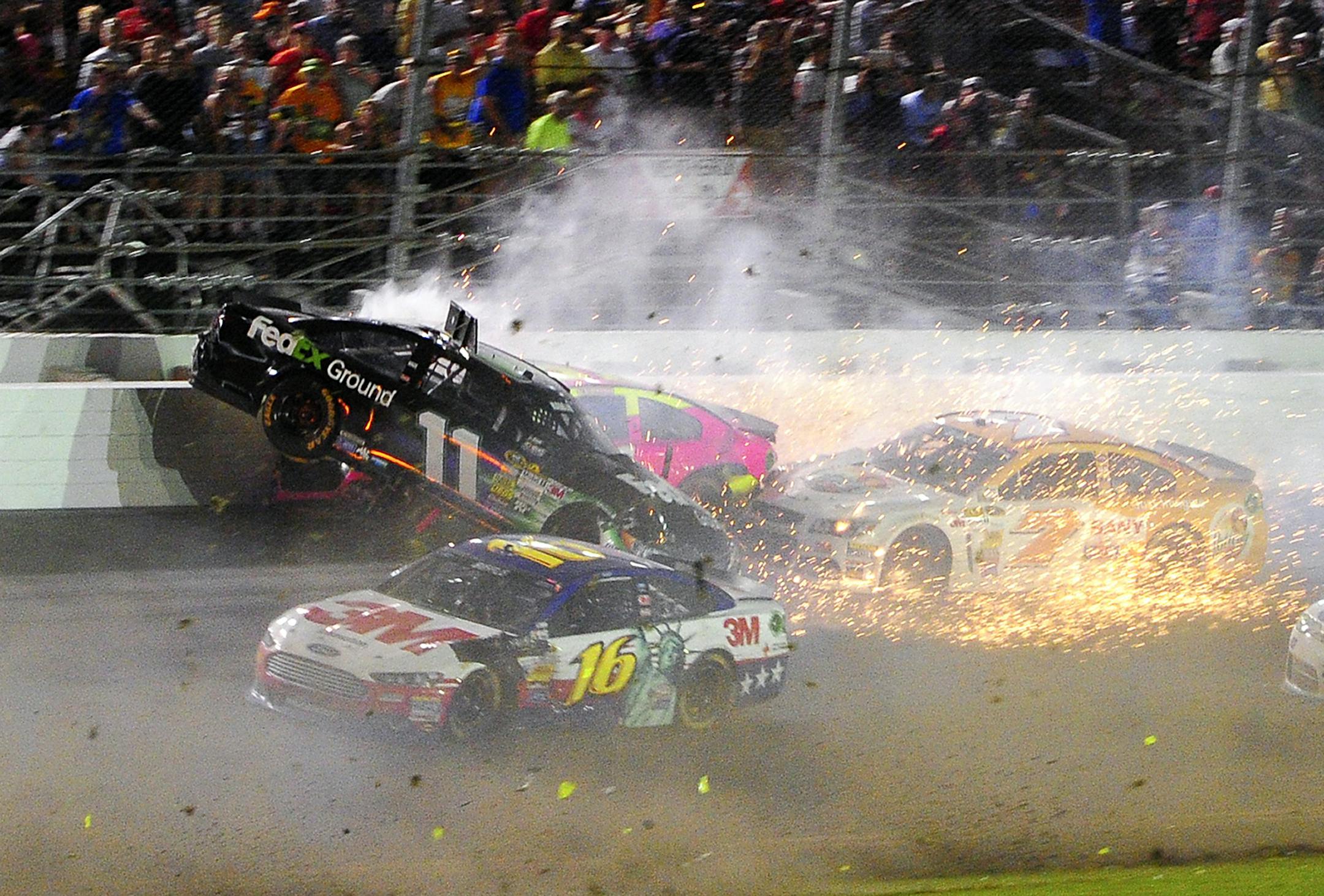 Denny Hamlin (11) hits the wall as he wrecks with A J Allmendinger, back, and Dave Blaney (7) as Greg Biffle (16) drives past in the NASCAR Sprint Cup auto race at Daytona International Speedway, Saturday, July 6, 2013, in Daytona Beach, Fla. (AP Photo/David Yeazell)