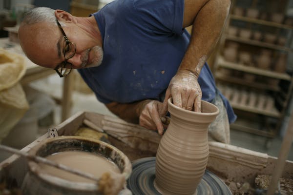 Potter Mark Connolly 'throwing' a pitcher at Red Wing Pottery.