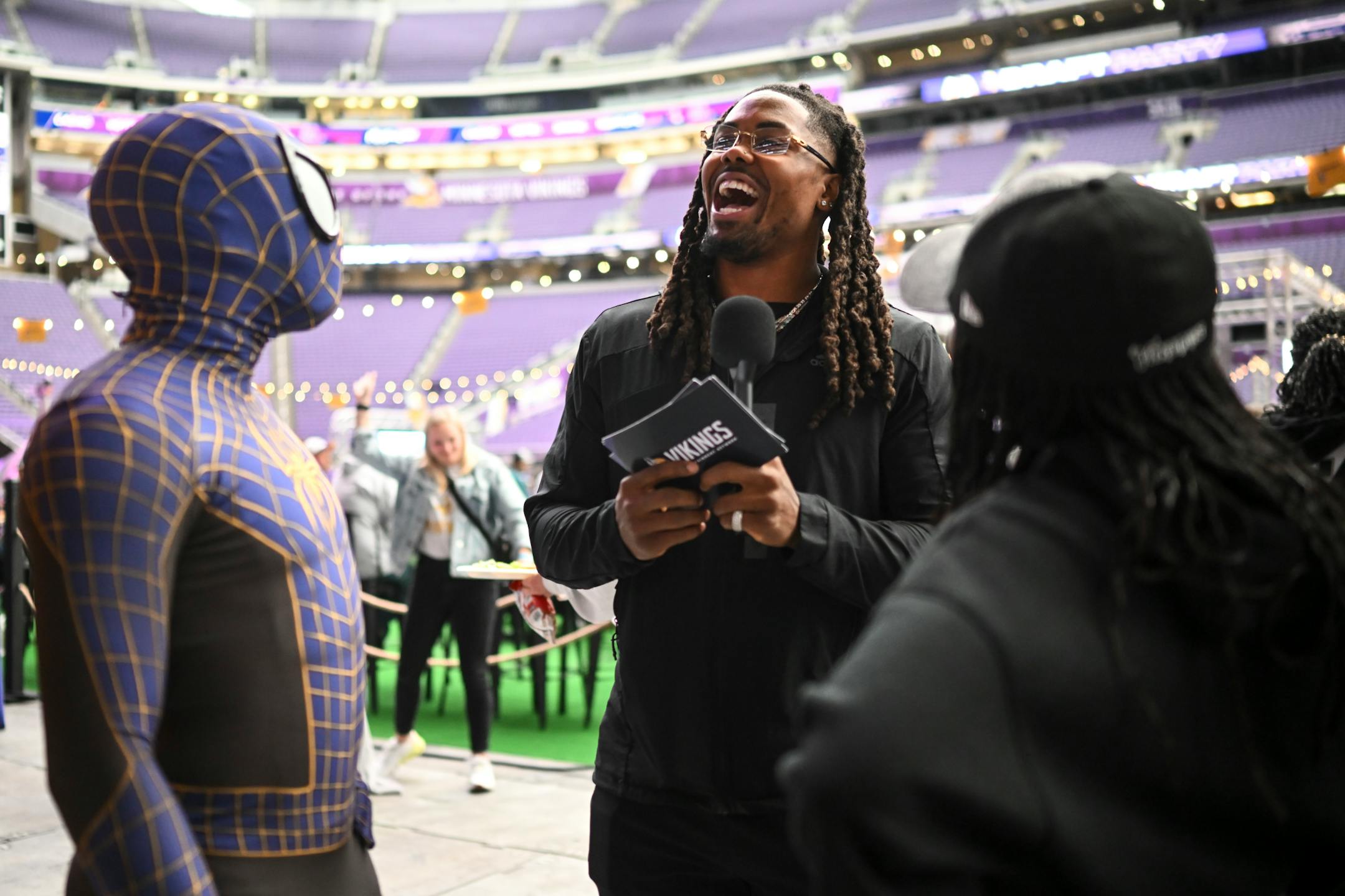 Minnesota Vikings wide receiver K.J. Osborn interviews fans, including JT Jackson, left, the "Skulltacular Spiderman," and his sister London Jackson, both of Eagan, during the Vikings NFL Draft Party.