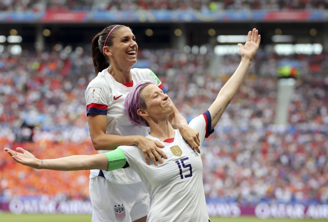 Megan Rapinoe, right, celebrates after scoring the opening goal from the penalty spot.