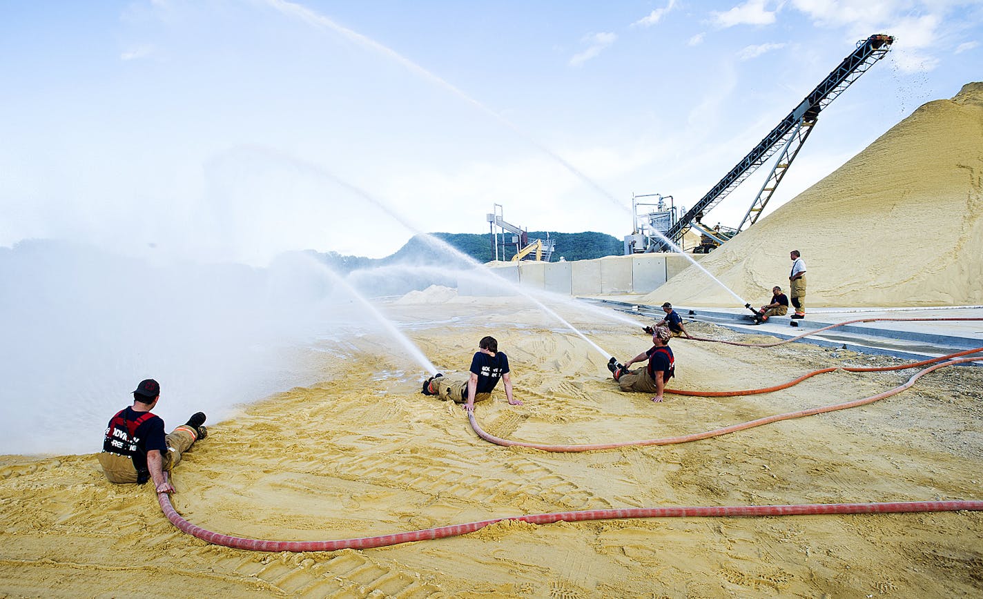 ADVANCE FOR MONDAY, AUG. 18 - Firefighters from Goodivew, Wilson, Minnesota City, Pickwick and Winona team up for pump operations training July 15, 2014, in Winona, Minn. (AP Photo/Winona Daily News, Andrew Link)