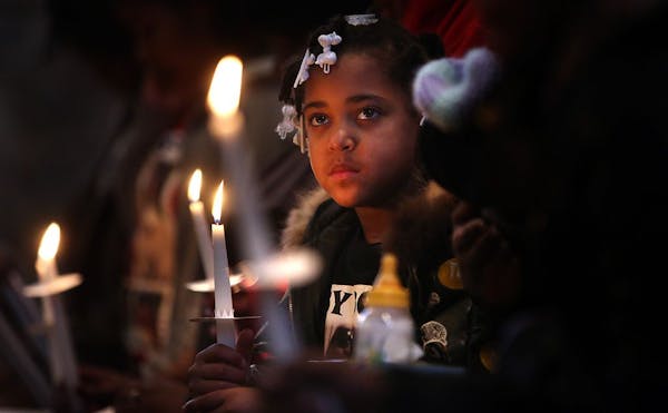 Seven-year-old Bre Frazier listened to the reading of names of loved ones who have been killed by violence during a memorial service. Bre's cousin, Pa