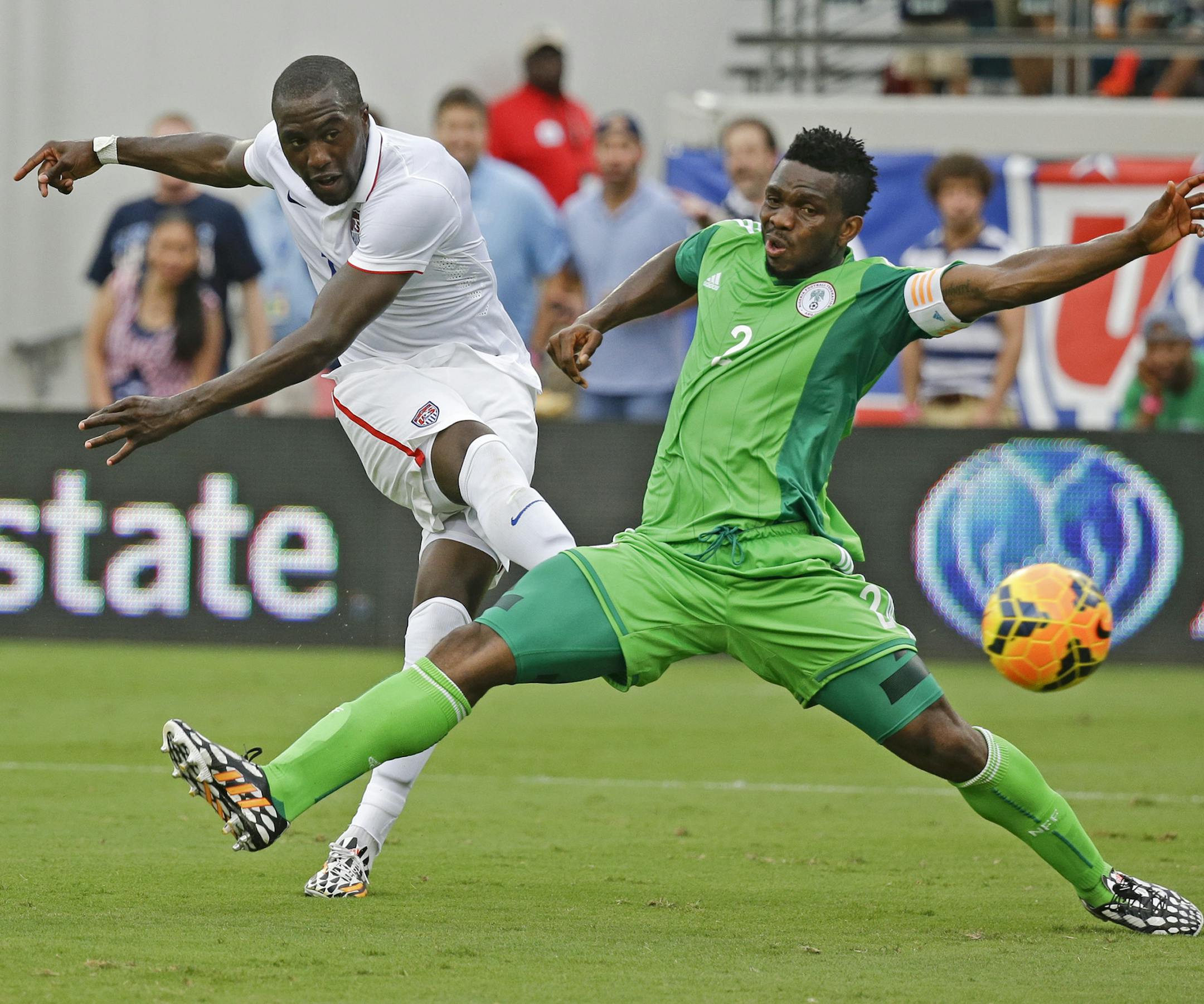 United States's Jozy Altidore, left, scores a goal as he kicks the ball past Nigeria's Joseph Yobo, right, during the second half of an international friendly soccer match in Jacksonville, Fla., Saturday, June 7, 2014. The United States won 2-1. (AP Photo/John Raoux)