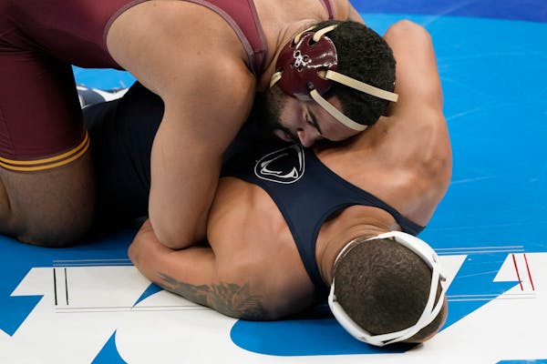 Minnesota's Gable Steveson, top, takes on Penn State's Greg Kerkvliet during their 285-pound match in the quarterfinal round of the NCAA wrestling cha