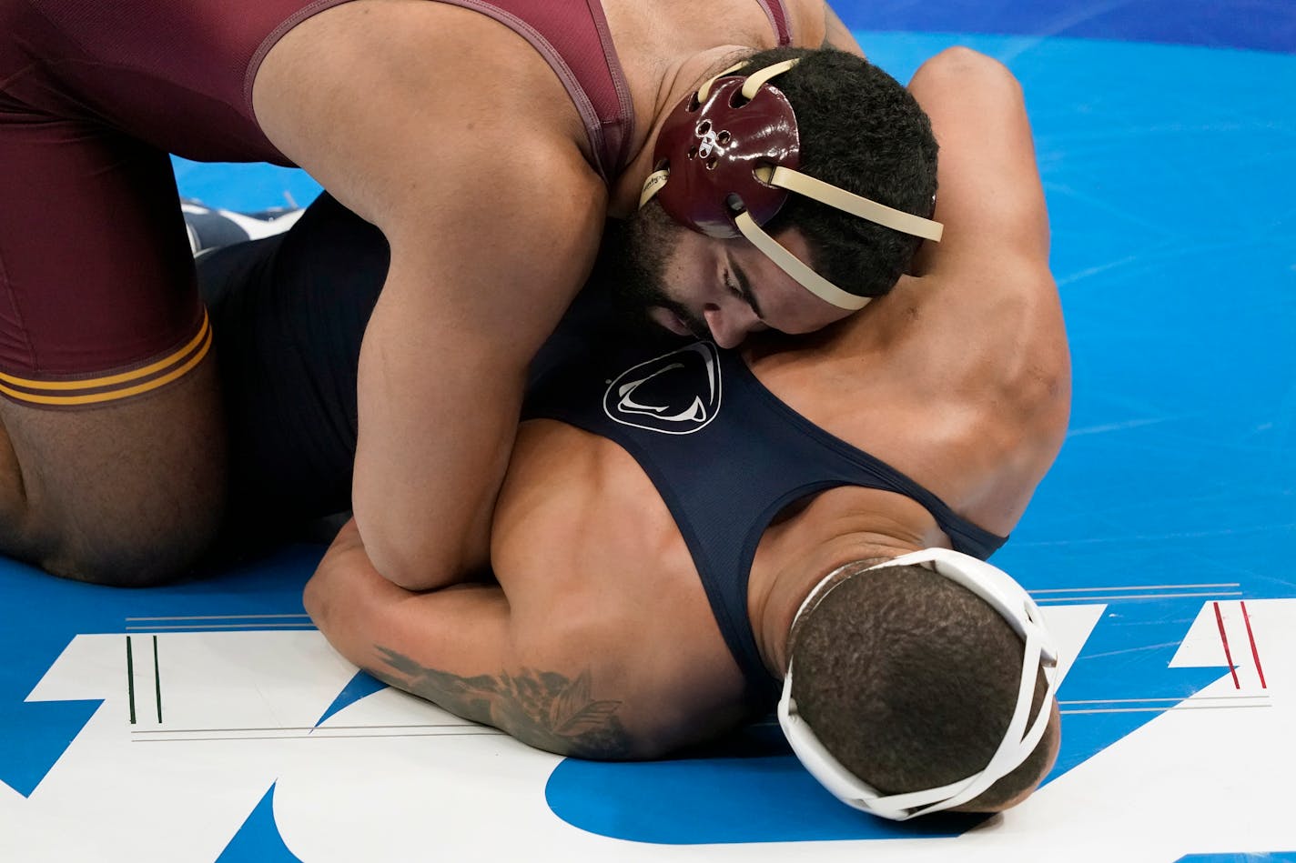 Minnesota's Gable Steveson, top, takes on Penn State's Greg Kerkvliet during their 285-pound match in the quarterfinal round of the NCAA wrestling championships Friday, March 19, 2021, in St. Louis. (AP Photo/Jeff Roberson)