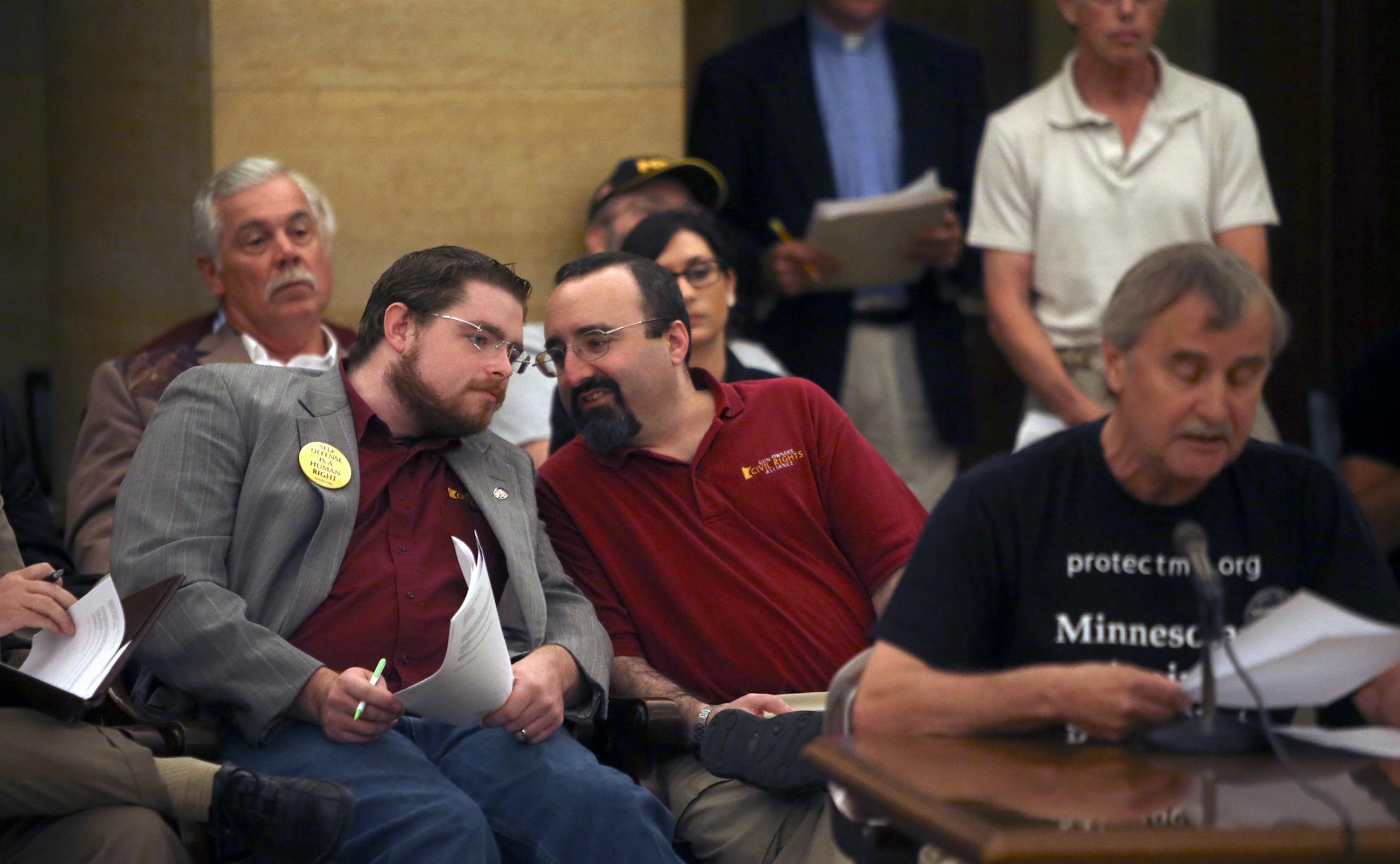 Gary Thompson of St. Paul, front right, testified against the carrying of firearms at the Capitol as gun proponents Don Doar, middle left to right, and Andrew Rothman chatted. During his testimony, Thompson accused Republican Rep. Tony Cornish, back left, who has a gun permit and carries, of being a bully on the issue.](DAVID JOLES/STARTRIBUNE) djoles@startribune.com During the second day of hearings on gun-carrying at the Capitol, comments from public were heard with both sides of the issue wei