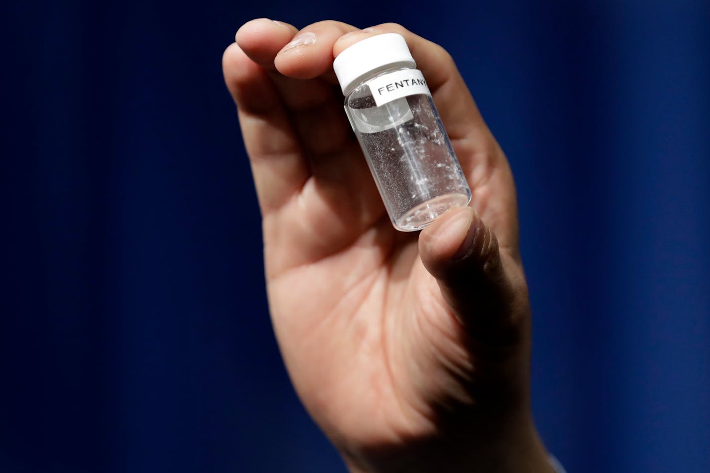 A reporter holds up an example of the amount of fentanyl that can be deadly after a news conference about deaths from fentanyl exposure, at DEA Headquarters in Arlington Va., Tuesday, June 6, 2017. (AP Photo/Jacquelyn Martin)