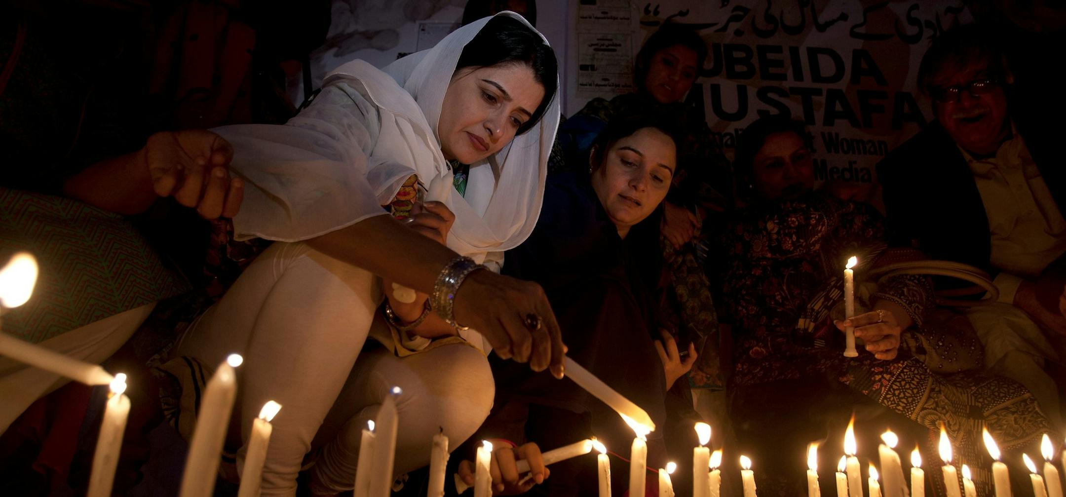 Pakistani women light candles to pay tribute to the victims of Thursday's suicide attack at a shrine, in Karachi, Pakistan, Friday, Feb. 17, 2017. A brutal attack on a beloved Sufi shrine that killed dozens of people raised fears that the Islamic State group has become emboldened in Pakistan, aided by an army of homegrown militants benefiting from hideouts in neighboring Afghanistan, analysts and officials said Friday. (AP Photo/Shakil Adil) ORG XMIT: ISL109