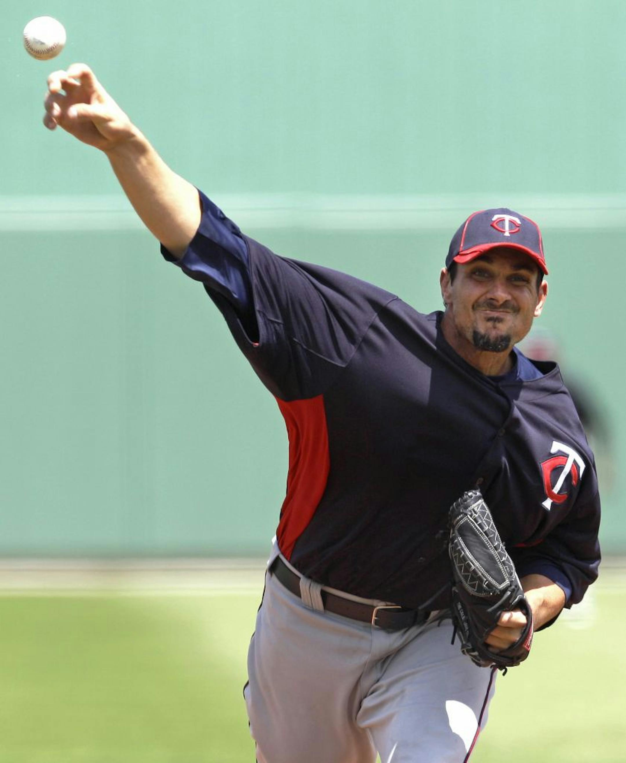 Minnesota Twins starter Carl Pavano delivers to the Boston Red Sox during the first inning of a spring training baseball game in Fort Myers, Fla., Sunday, April 1, 2012.