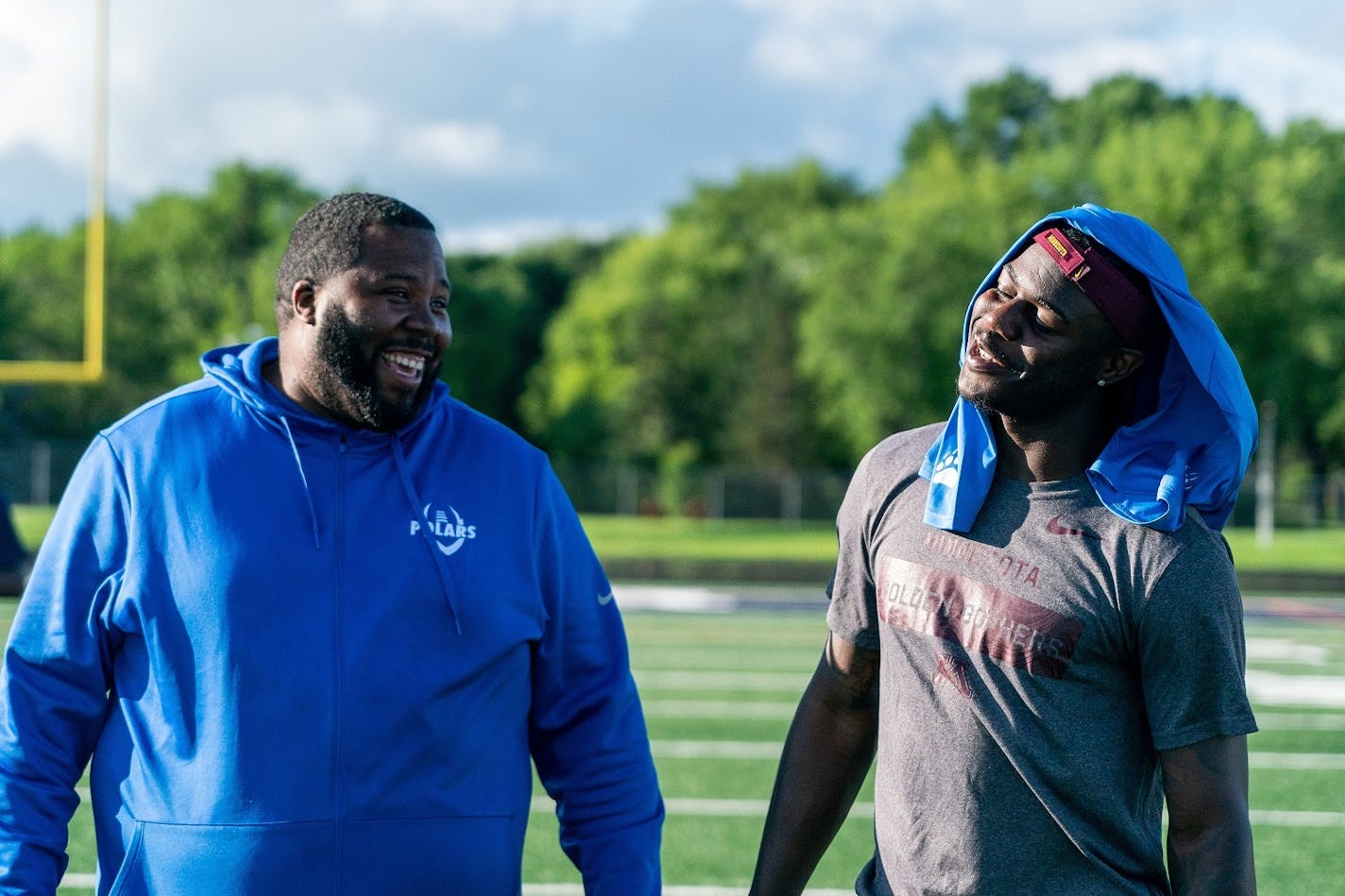 Polars head coach Charles Adams and Johnson catch up while the squad practices. ] MARK VANCLEAVE ¥ Minnesota Gophers wide receiver Tyler Johnson watched the Minneapolis North high school football team practice against other area teams during a scrimmage at Robbinsdale Cooper High School in New Hope on Wednesday, Jul 10, 2019.