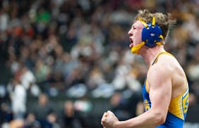 St. Michael-Albertville wrestler Noah Torgerson celebrates after defeating Apple Valley wrestler Marcell Booth.