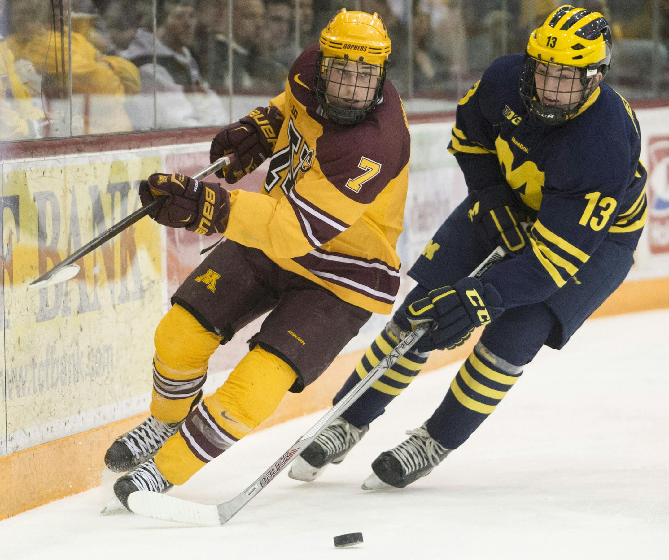Michigan's Zach Werenski (13) defends against Minnesota center Kyle Rau (7) as he tries to wrap around the back of Michigan's goal in the second period. ] (Aaron Lavinsky | StarTribune) Michigan plays against the University of Minnesota on Saturday, Feb. 14, 2015 at Mariucci Arena. ORG XMIT: MIN1502142157123930