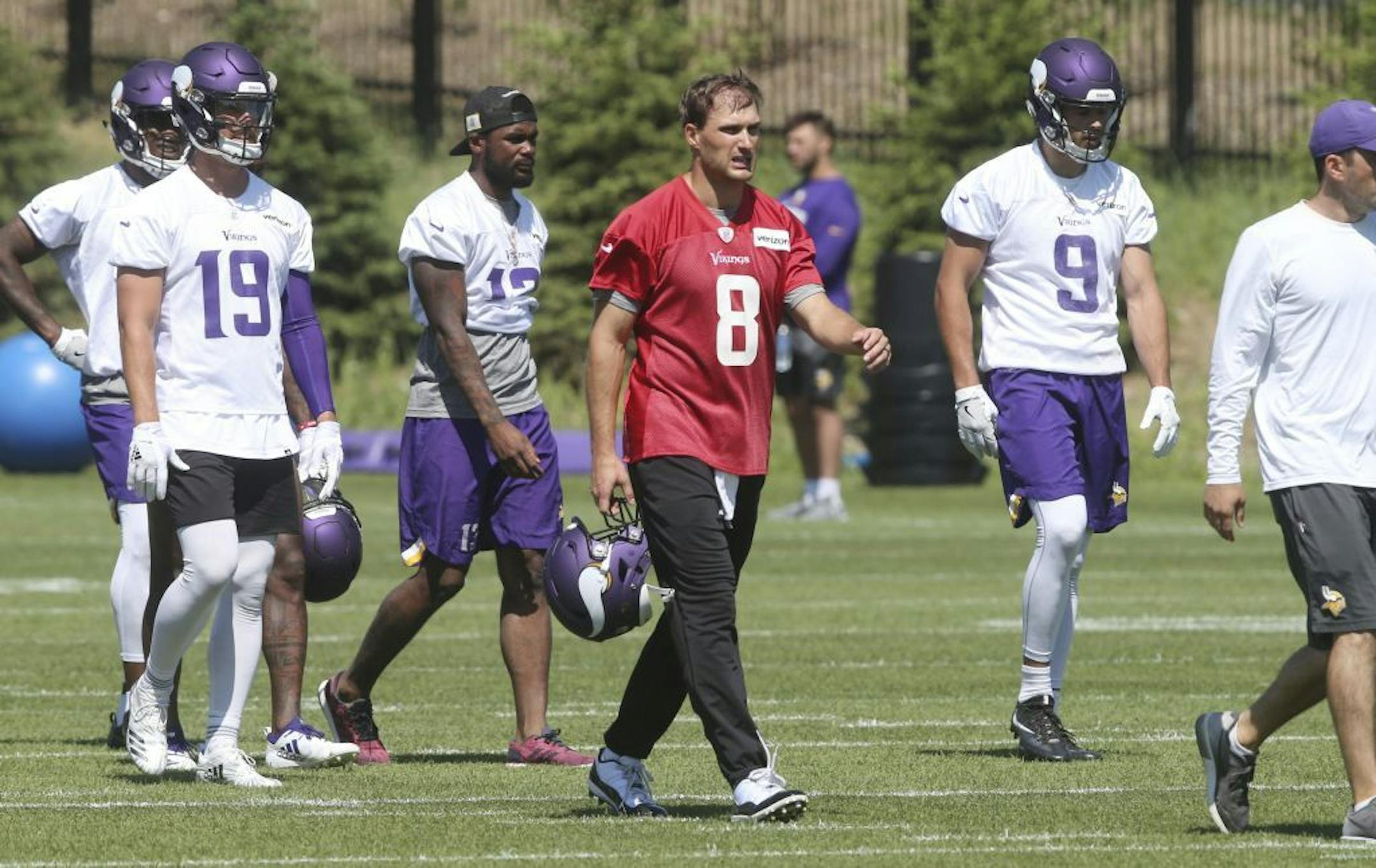 Minnesota Vikings quarterback Kirk Cousins (8) leads offensive players to another part of the field in practice at the NFL football team's training camp in Eagan, Minn., Tuesday, June 5, 2018.