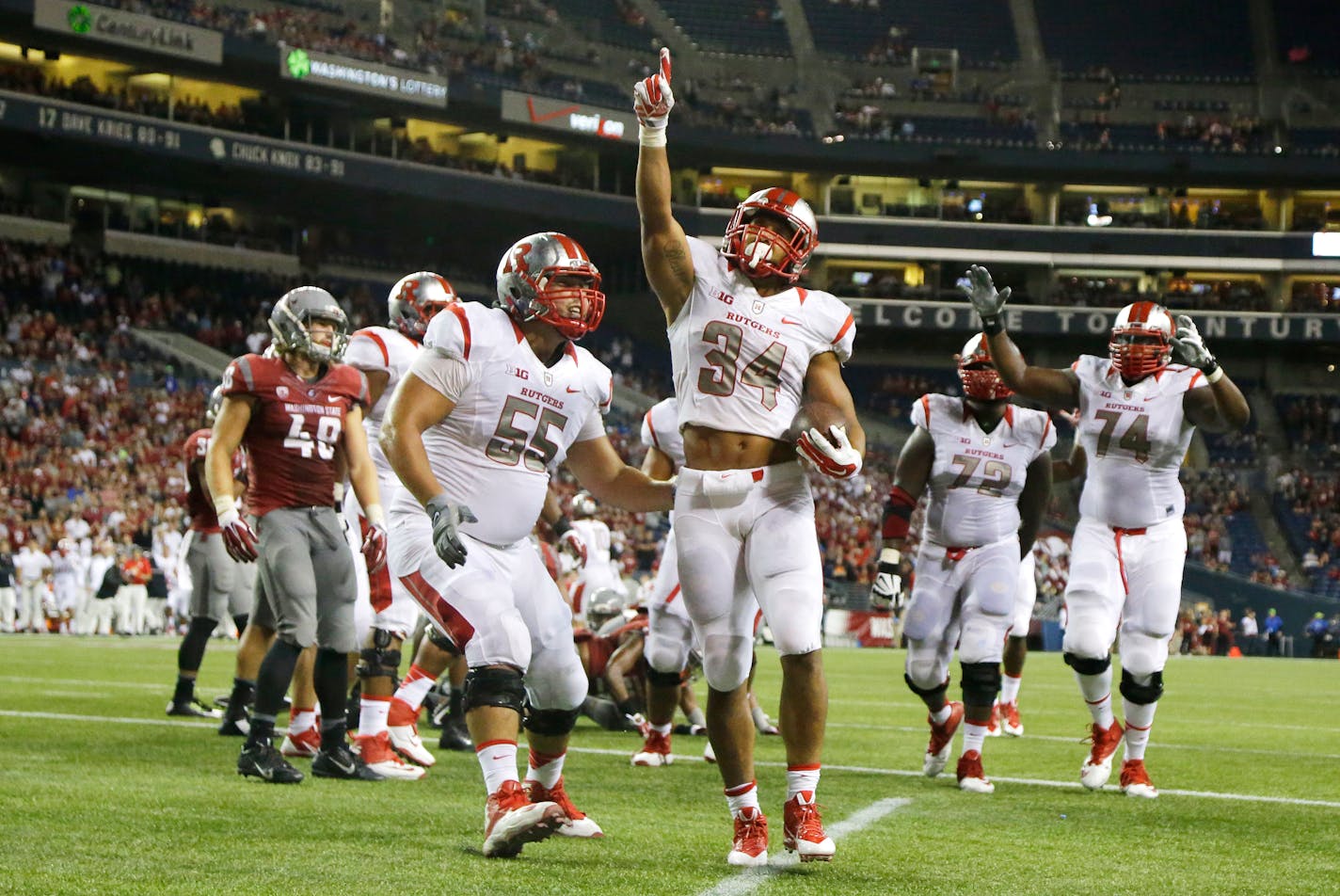 Rutgers running back Paul James (34) points upward after he rushed for a touchdown in the second half of an NCAA college football game against Washington State, Thursday, Aug. 28, 2014, in Seattle. Rutgers beat Washington State 41-38. (AP Photo/Ted S. Warren)