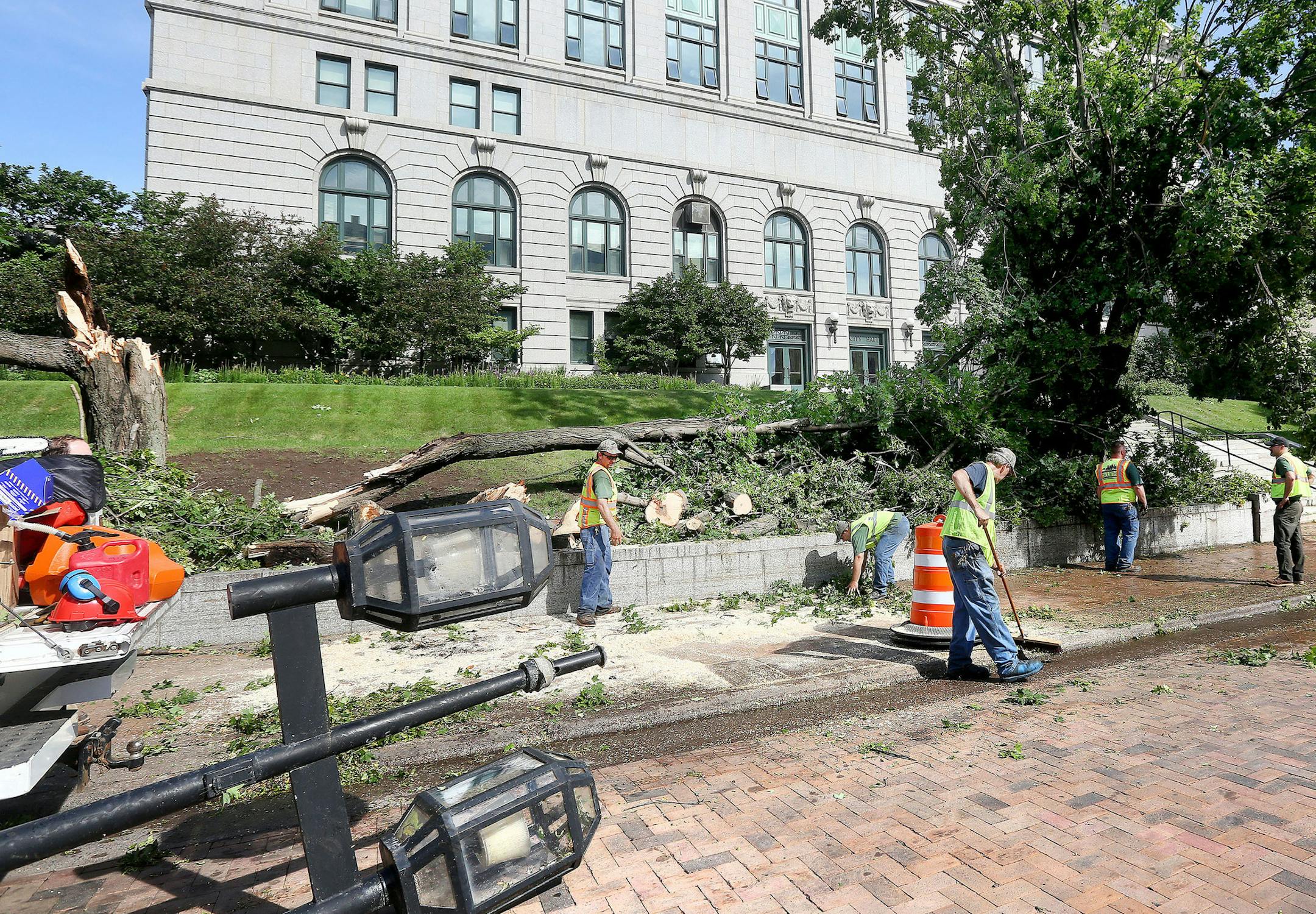 t7.21.116 Bob King -- kingSTORM0922c16 -- City workers clean up limbs from a fallen tree in front of City Hall Thursday morning. At left is a streetlamp that was also knocked over by the wind from the storm. MANDATORY CREDIT: Bob King / rking@duluthnews.com