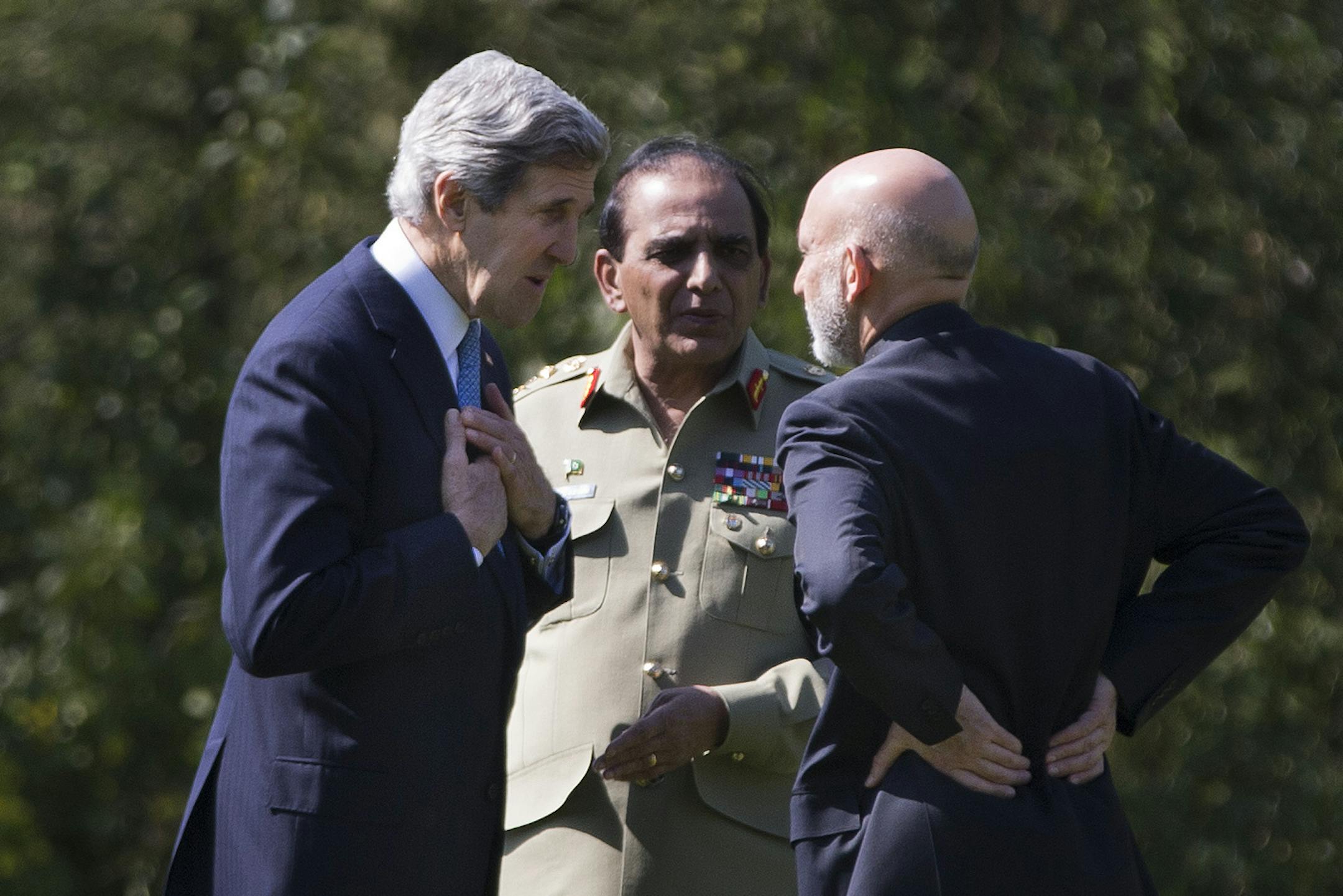 U.S. Secretary of State John Kerry, left, talks with Afghan President Hamid Karzai, right, and Pakistani Army Chief Gen. Asfhaq Parvez Kayani as they take a walk during a break in a meeting on Wednesday, April 24, 2013, in Brussels, Belgium. The trilateral meeting is to discuss regional security issues, and the 2014 withdrawal of NATO combat forces from Afghanistan. (AP Photo/Evan Vucci, Pool) ORG XMIT: MIN2013042819123634