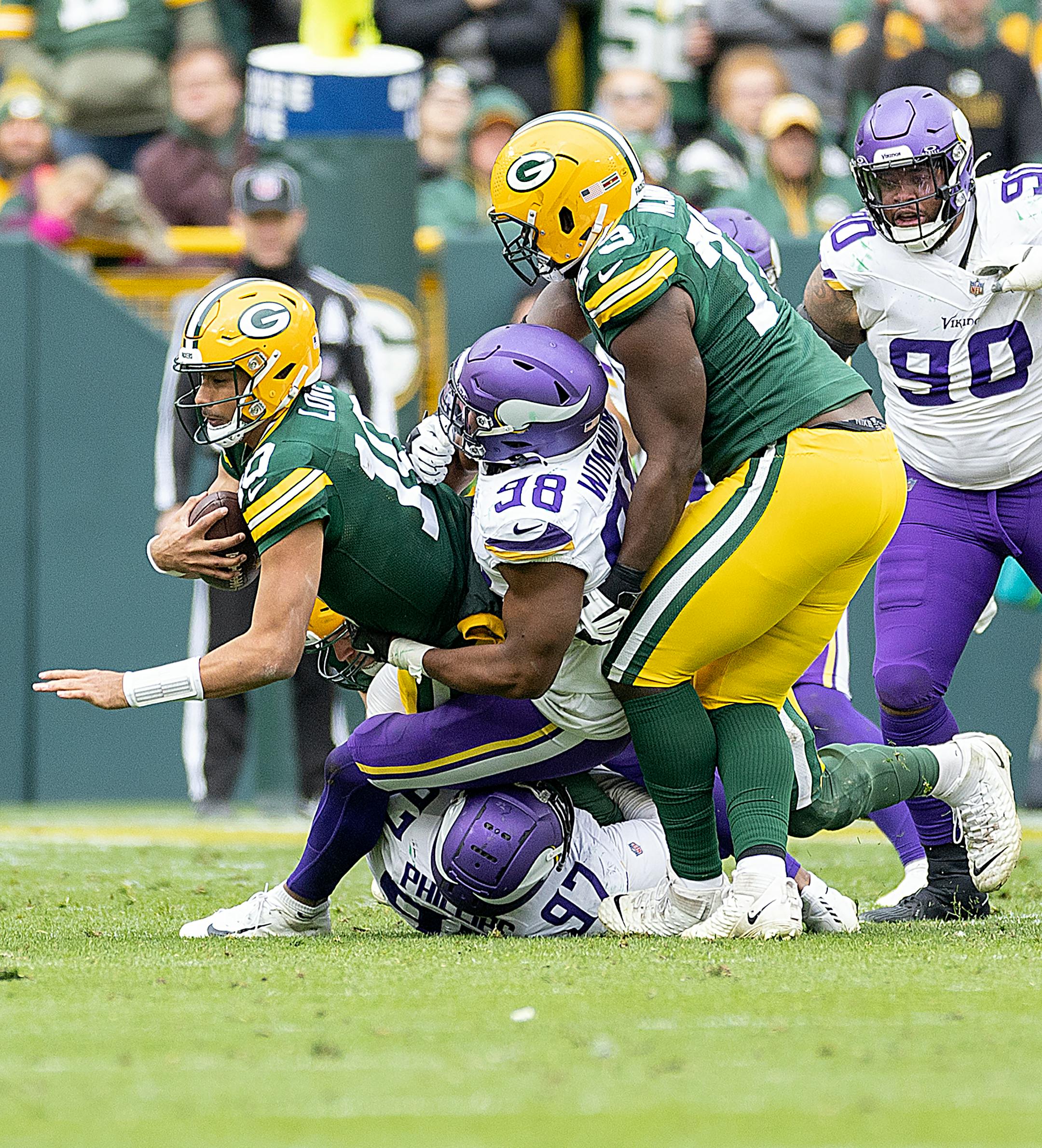 Packers quarterback Jordan Love (10) is taken down by Vikings defensive tackle Harrison Phillips (97), below, and Vikings linebacker D.J. Wonnum (98) in the fourth quarter at Lambeau Field in Green Bay, Wis., on Sunday, Oct. 29, 2023. ] Elizabeth Flores • liz.flores@startribune.com