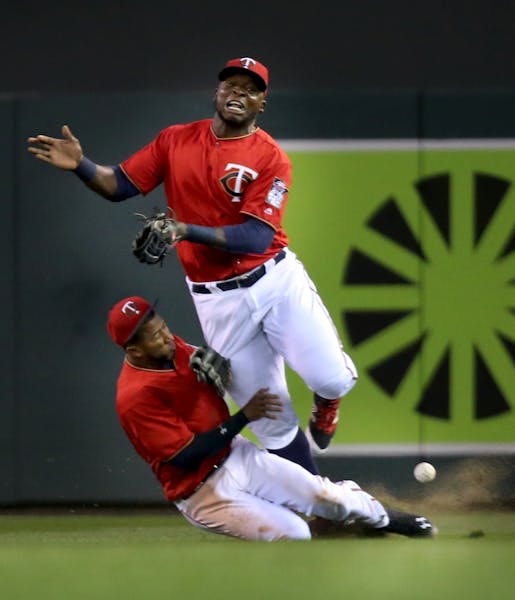 Minnesota Twins right fielder Miguel Sano, top, and second baseman Eduardo Nunez collide in right field while chasing a fly ball hit by the LA Angels 