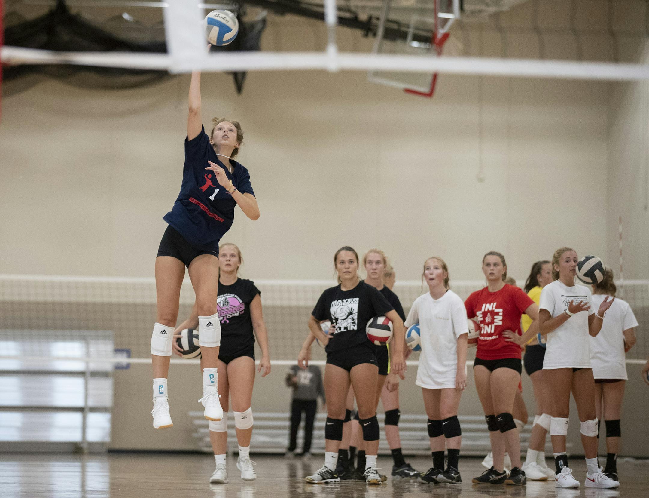 Olivia Tjernagel served the ball during the first day of volleyball practice Monday at Mayer Lutheran High School. Photo: Jerry Holt • Jerry.holt@startribune.com