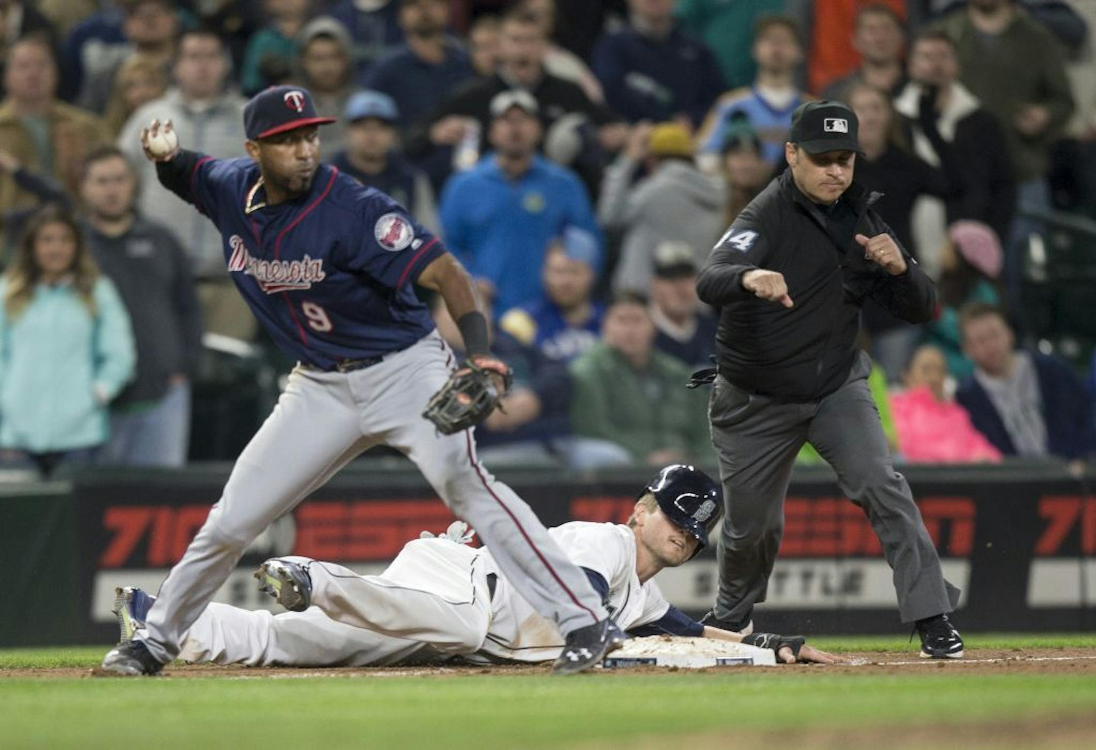 Seattle Mariners' Shawn O'Malley lays on the ground after being tagged out caught stealing by Minnesota Twins third baseman Eduardo Nunez who threw to second to complete a double play in the ninth inning of a baseball game, on Saturday, May 28, 2016, in Seattle. The Twins won 6-5.