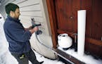 At a home in St. Louis Park, Robert W. Carlson, owner of Healthy Homes drills a hole through the basement wall. The fan on the right is part of a miti