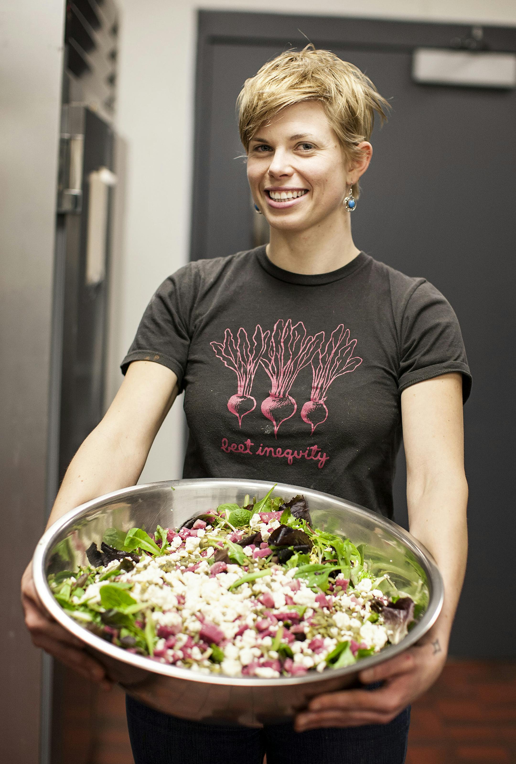 Emily Torgrimson holds a salad at Eat for Equity's community feast benefitting Urban Ventures at the Urban Ventures headquarters in Minneapolis January 31, 2015. (Courtney Perry/Special to the Star Tribune)
