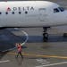 In this Feb. 5, 2019, file photo a ramp worker guides a Delta Air Lines plane at Seattle-Tacoma International Airport in Seattle. (AP Photo/Ted S. War