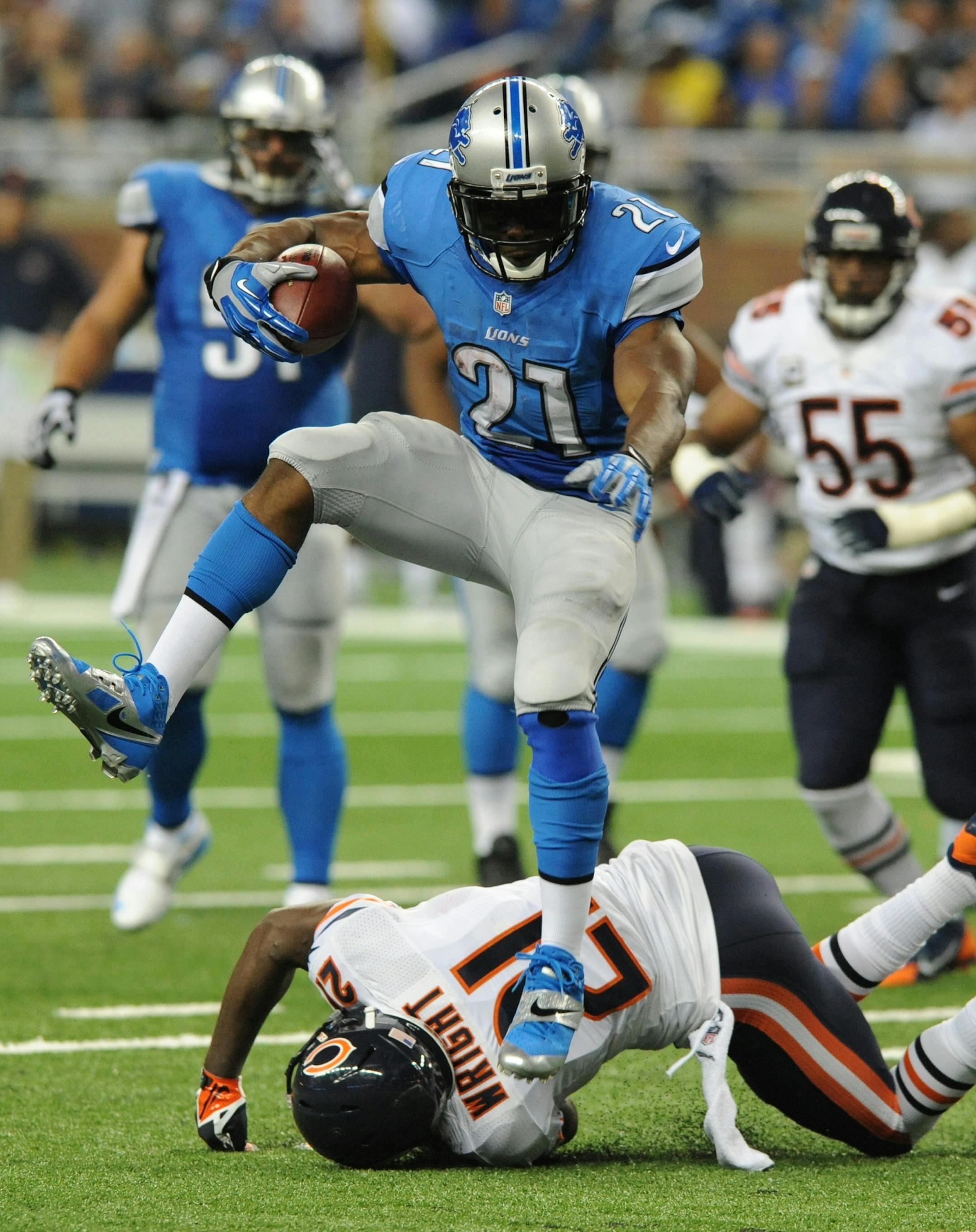 Detroit Lions running back Reggie Bush (21) jumps over Chicago Bears strong safety Major Wright (21) as he runs for a 37-yard touchdown during the second quarter of an NFL football game at Ford Field in Detroit, Sunday, Sept. 29, 2013. (AP Photo/Jose Juarez)