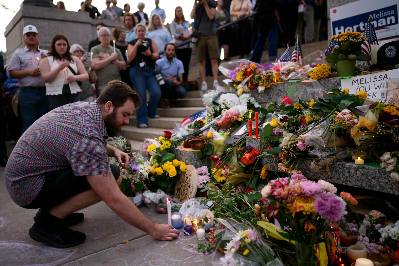 Colin Hortman, son of Melissa and Mark Hortman, places a candle during the candlelight vigil for his parents at the State Capitol in St. Paul, Minn., Wednesday, Jun 18, 2025. 