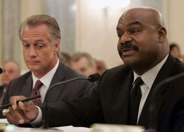 Former Chicago Bears safety Dave Duerson, trustee for the Burt Bell/Pete Rozell NFL Player Retirement Plan, right, accompanied by former Dallas Cowboy