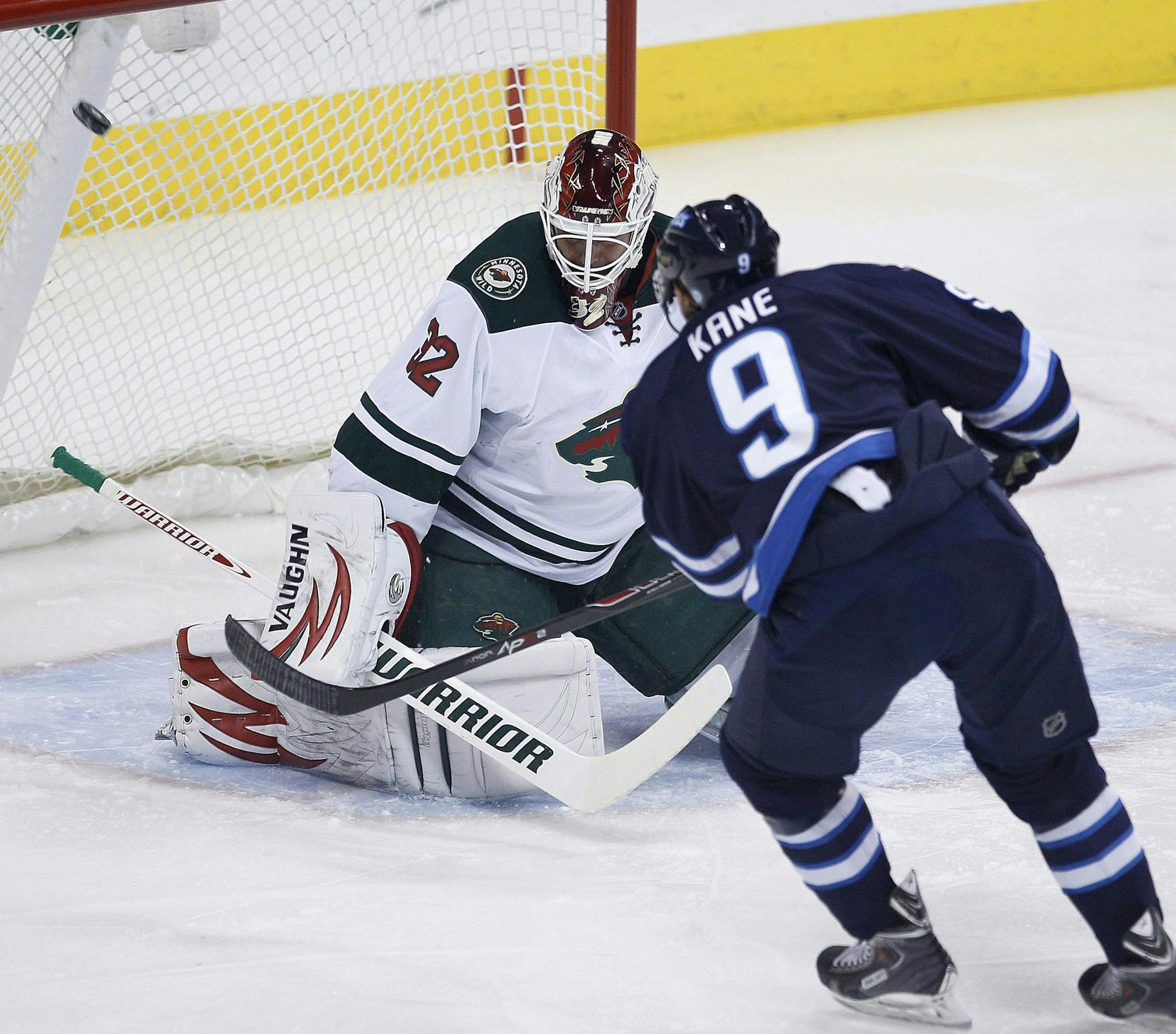 Winnipeg Jets' Evander Kane (9) scores on Minnesota Wild's goaltender Niklas Backstrom (32) during first-period NHL hockey game action in Winnipeg, Manitoba, Friday, Dec. 27, 2013. (AP Photo/The Canadian Press, John Woods)