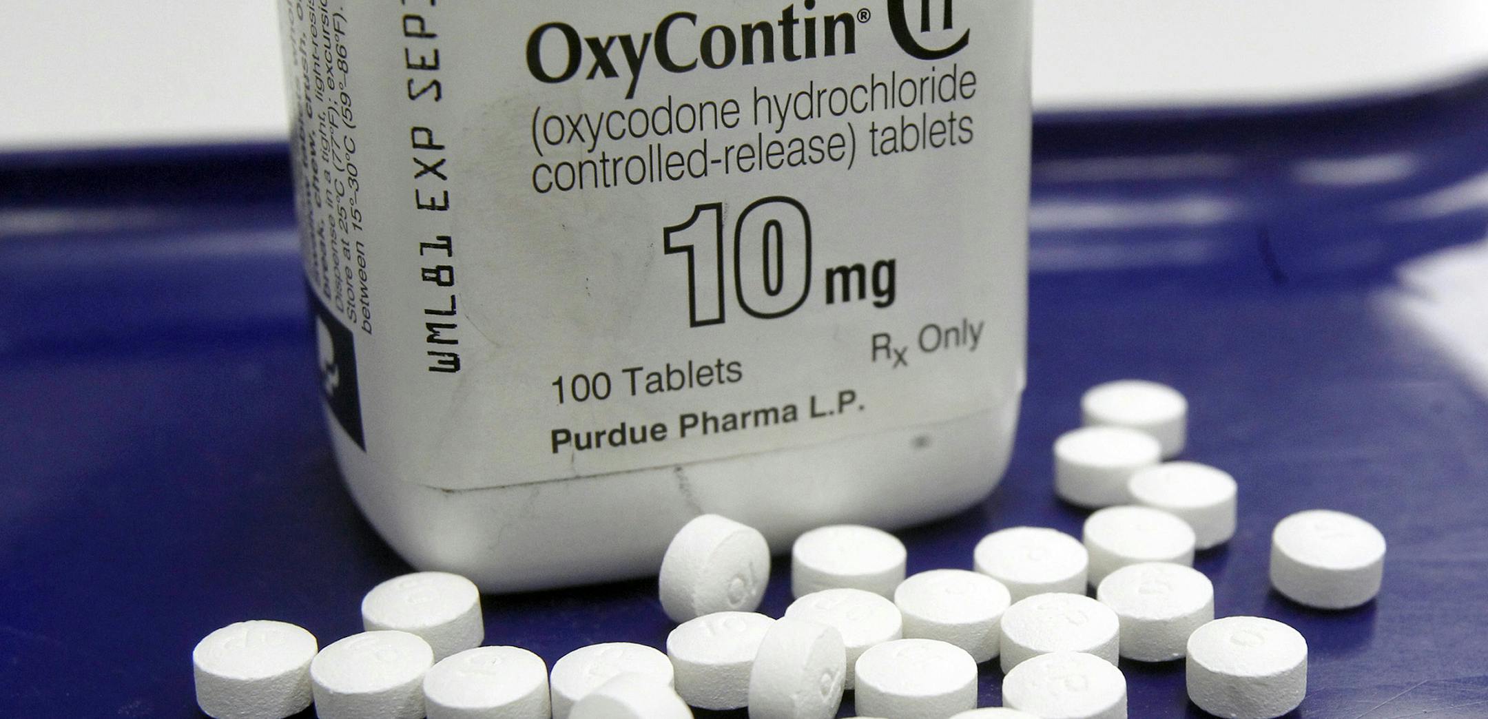 FILE - This Feb. 19, 2013, file photo, shows OxyContin pills arranged for a photo at a pharmacy in Montpelier, Vt. Overdoses don't happen just to heroin addicts _ patients who legally use strong painkillers called opioids are at risk in the nation&#x2019;s epidemic, too. A new study says when patients were prescribed an overdose antidote along with those medications, they made fewer painkiller-related visits to the emergency room. The study released on June 27, 2016, went a step further _ to see