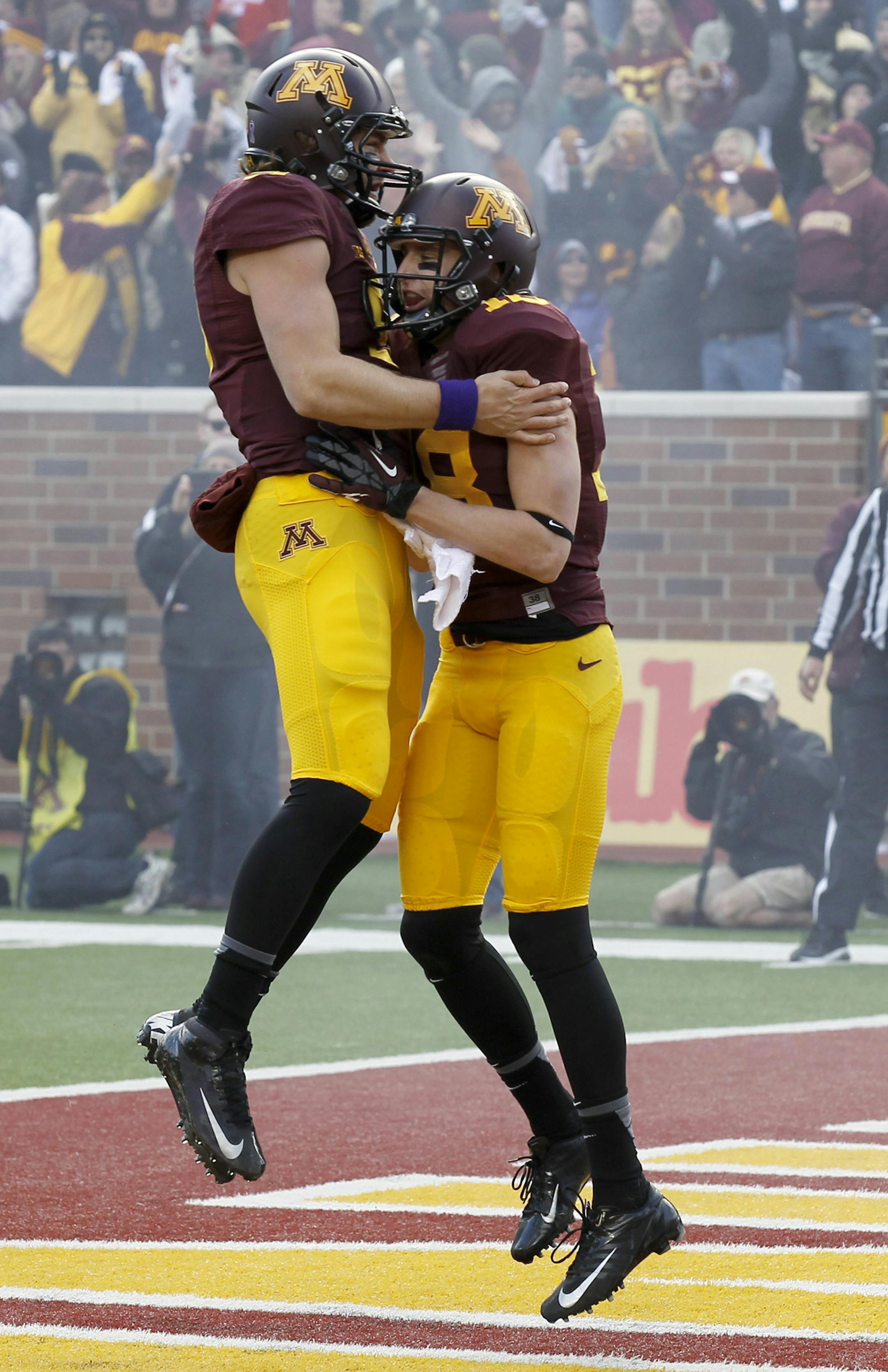 Minnesota quarterback Philip Nelson, left, and wide receiver Derrick Engel, right, celebrate Engel's touchdown during the second quarter of an NCAA college football game against Nebraska in Minneapolis, Saturday, Oct. 26, 2013. (AP Photo/Ann Heisenfelt)