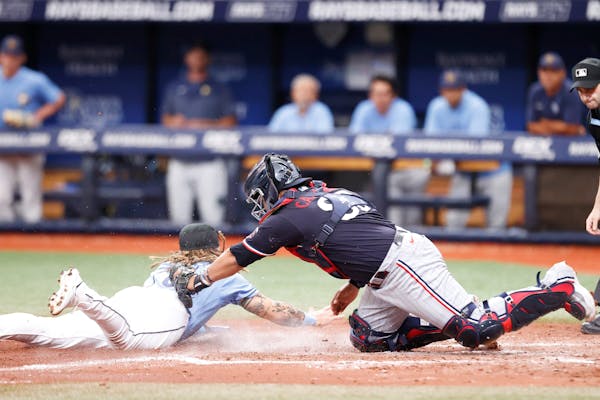 Niko Hulsizer of the Rays slid past the tag of Twins catcher Jair Camargo at St. Petersburg, Fla., on Tuesday.