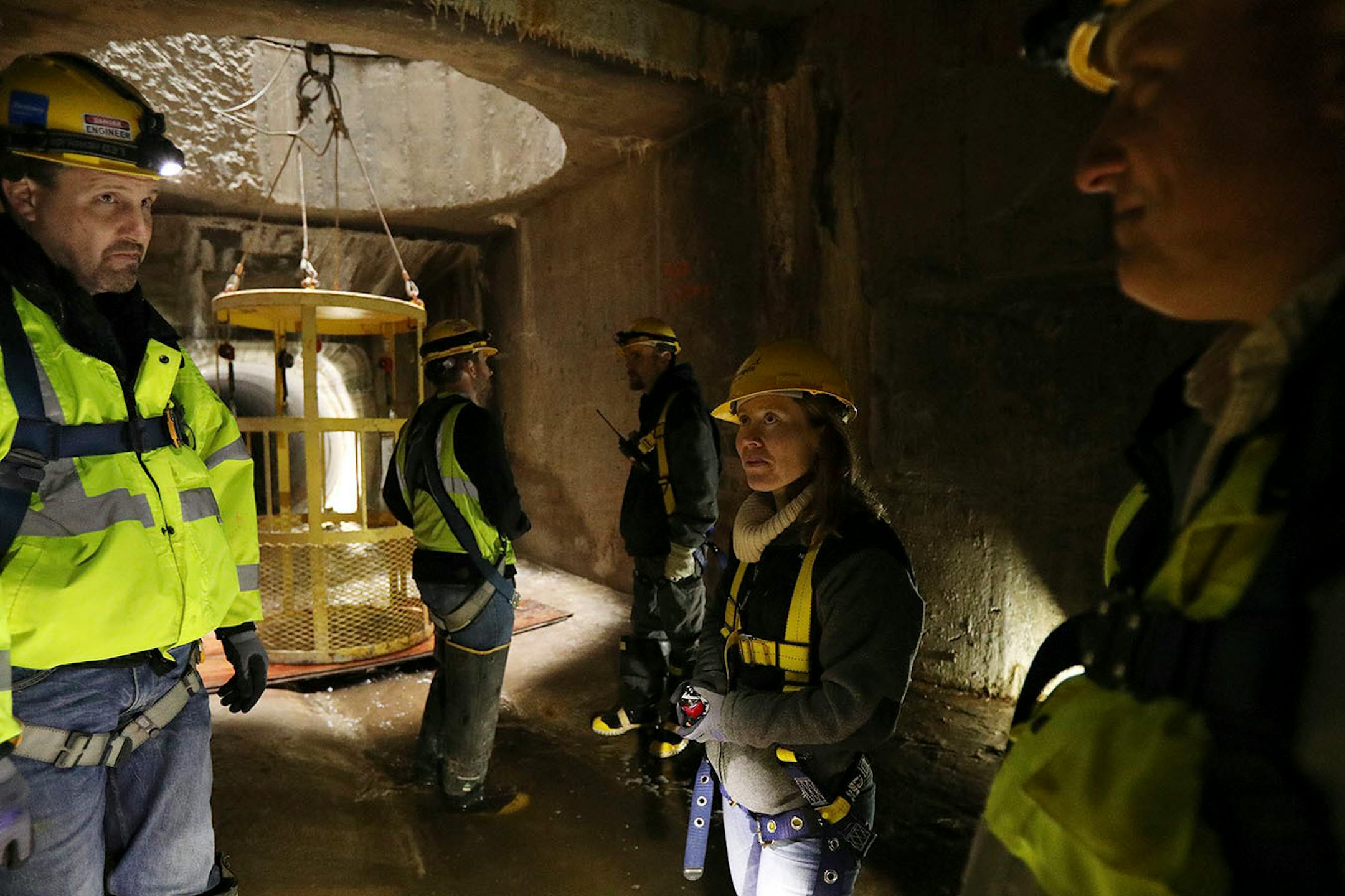 Katrina Kessler, center, director of Surface Water and Sewers for the Minneapolis Public Works Department, talked with sewer operations engineer Kevin Danen, left, and sewer engineer Joe Klejwa, right, during a tour underground of the city's storm sewers in the northeast.