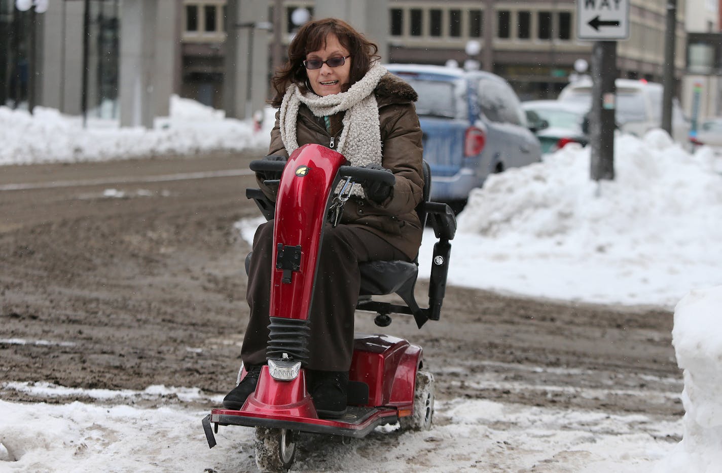 Joan Willshire had to go out into traffic to get a jump start to be able to get over onto the sidewalk on a St. Paul street near her work, Friday, February 28, 2014. Willshire, who has MS, has been advocating a lot this winter for safer sidewalks/streets for people with disabilities. ] (ELIZABETH FLORES/STAR TRIBUNE) ELIZABETH FLORES &#x2022; eflores@startribune.com