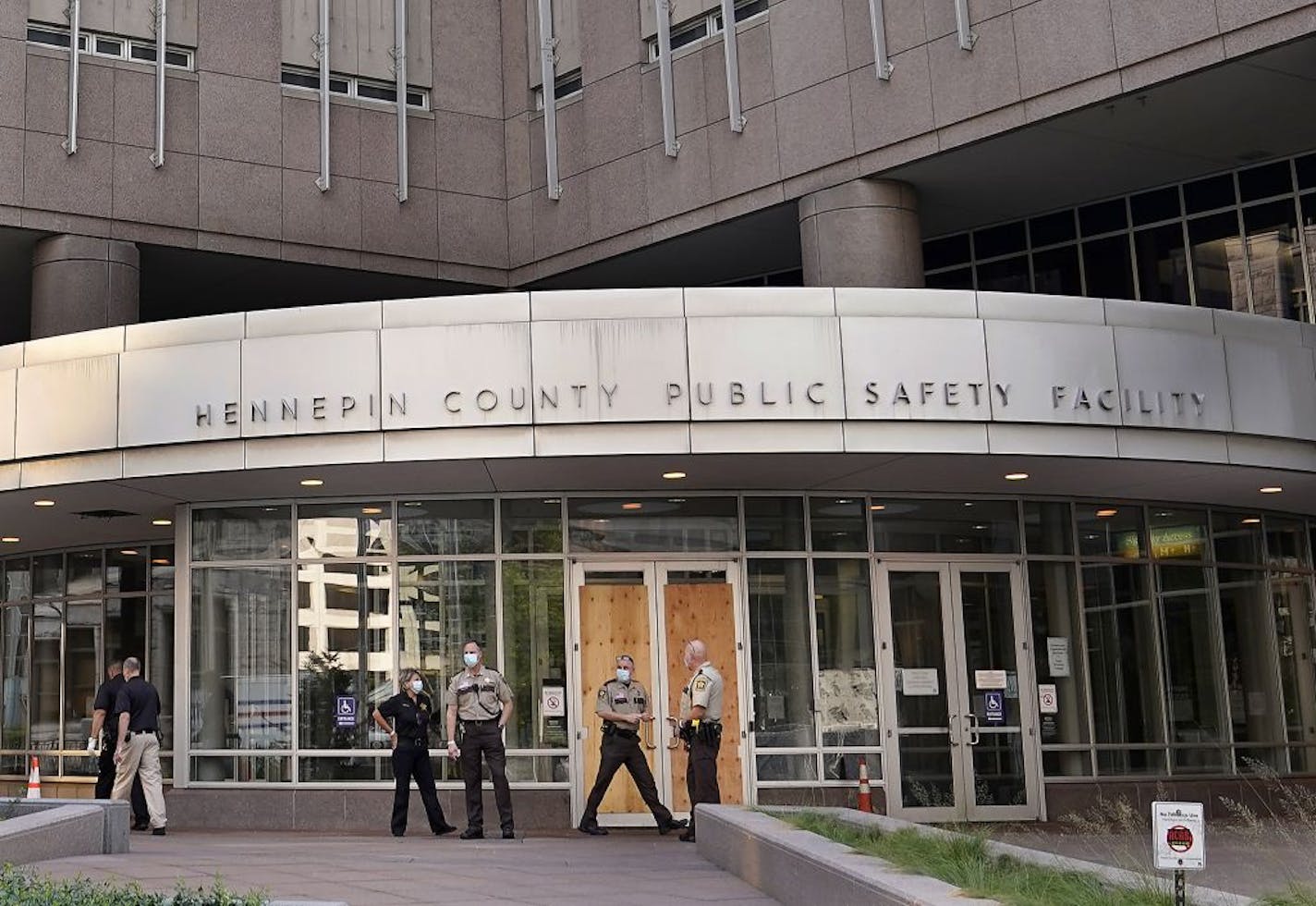 Law enforcement officers outside the Hennepin County Public Safety Facility Tuesday morning, where a demonstration in response to the police shooting of a black man in Kenosha, Wisc., turned destructive late Monday, where protesters broke front entry door windows to the jail.