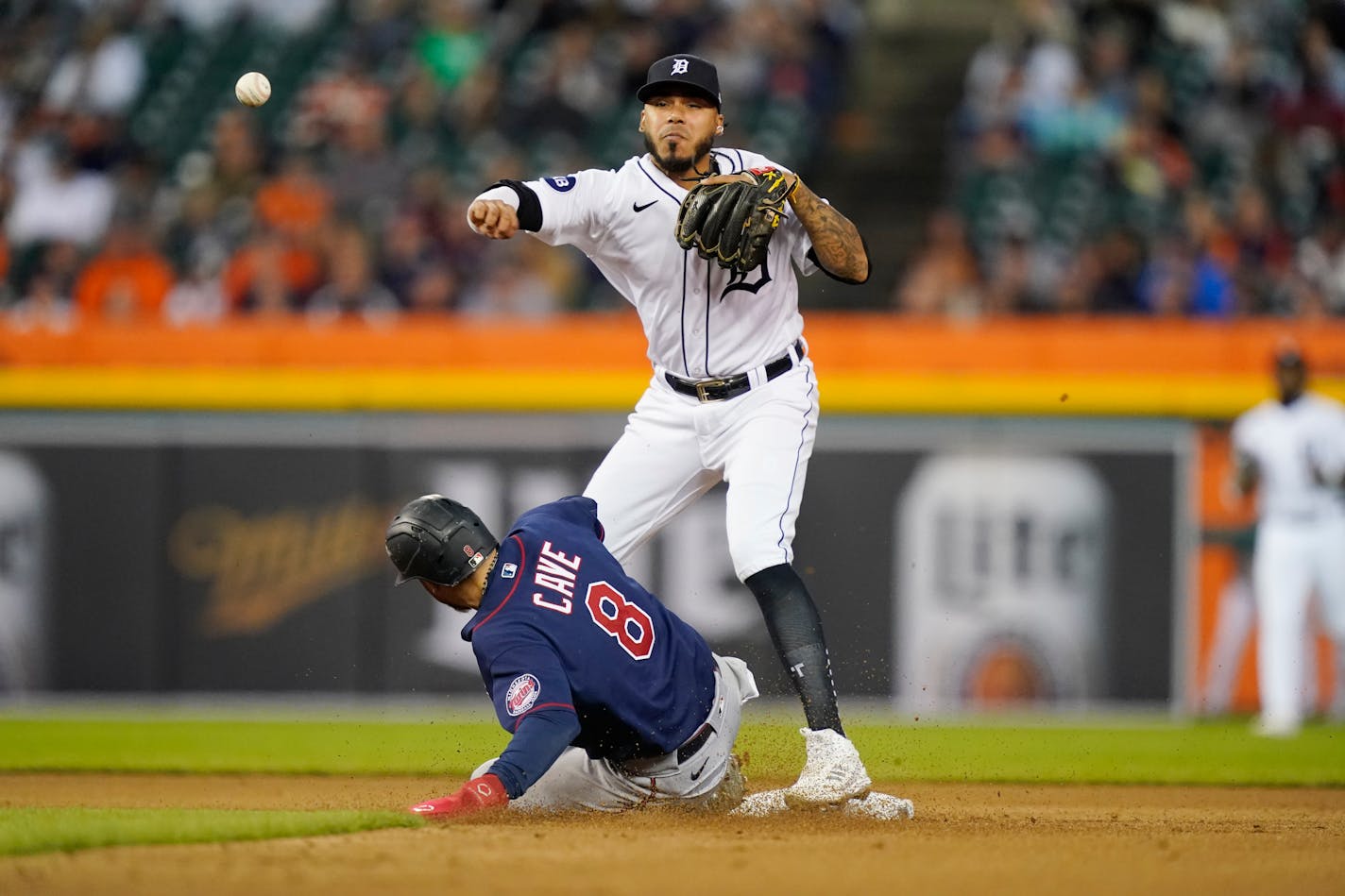 Tigers second baseman Harold Castro throws to first base over the Twins' Jake Cave for a double play hit into by Gary Sanchez during the fourth inning Saturday