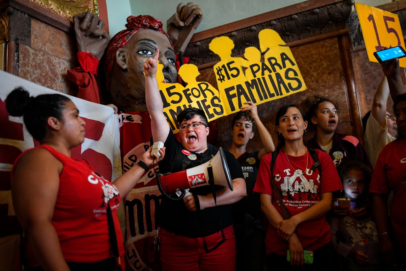 Cat Salonek, an activist with the Communication Workers of America, led a chant for a $15 minimum wage outside of the Minneapolis City Hall chambers Thursday afternoon. ] AARON LAVINSKY &#xef; aaron.lavinsky@startribune.com The Minneapolis City Council heard public comments on the $15 minimum wage ordinance at a public hearing on Thursday, June 22, 2017 at Minneapolis City Hall.