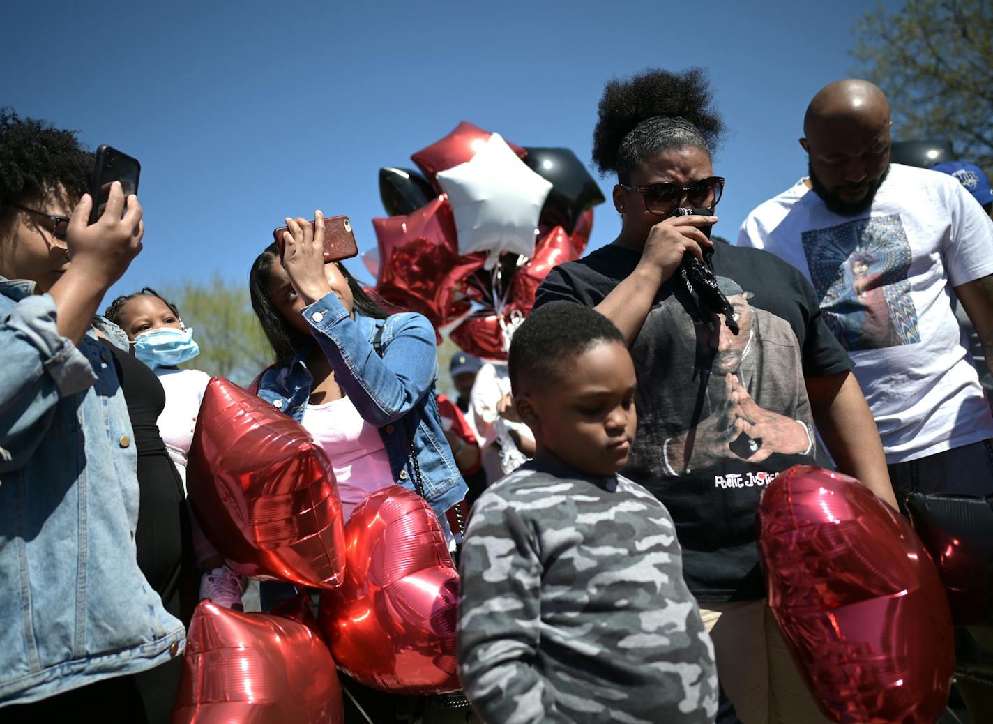 Around 50 mourners gathered on the Burns Avenue scenic overlook in St. Paul on Sunday afternoon for a memorial balloon release in honor of Douglas Lewis, left. Friends and family grieved the loss of Lewis, who was shot to death Friday night.