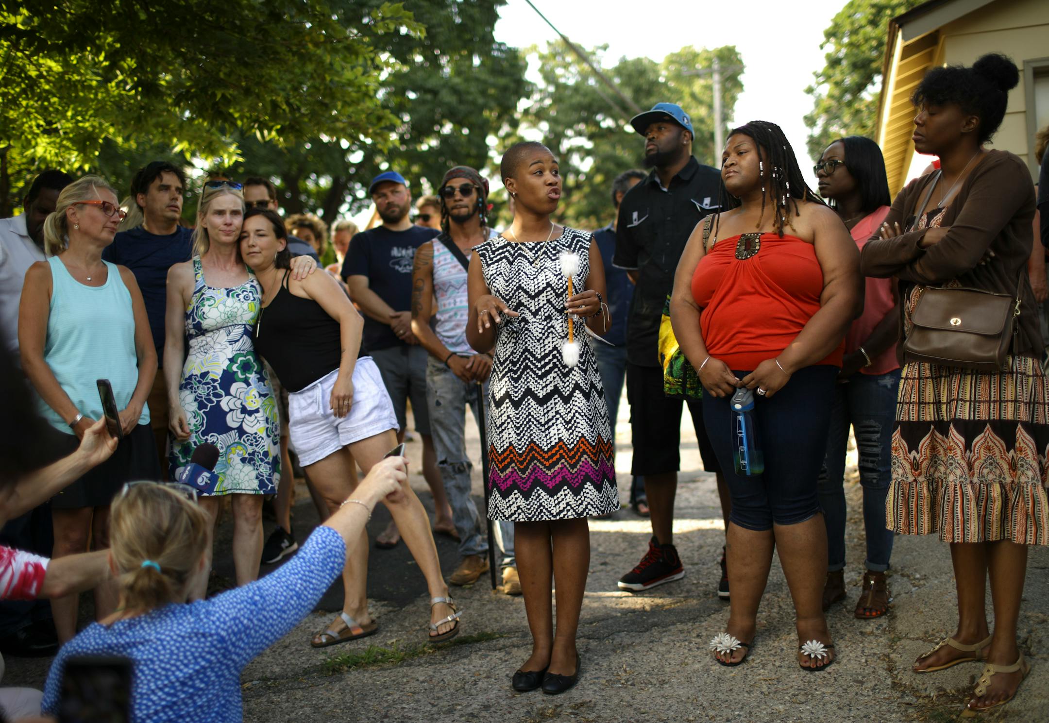 Bethany Bradley leaned over to hug Melinda Barry as Leslie Redmond of the NAACP of Minneapolis began to speak to those gathered to remember Sunday evening.