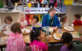 Anna Zimmermann Jin, center, eats lunch with daughter Ella Zimmermann Jin, 6, to her right, and fellow first-graders during lunch at Lake Harriet Elem