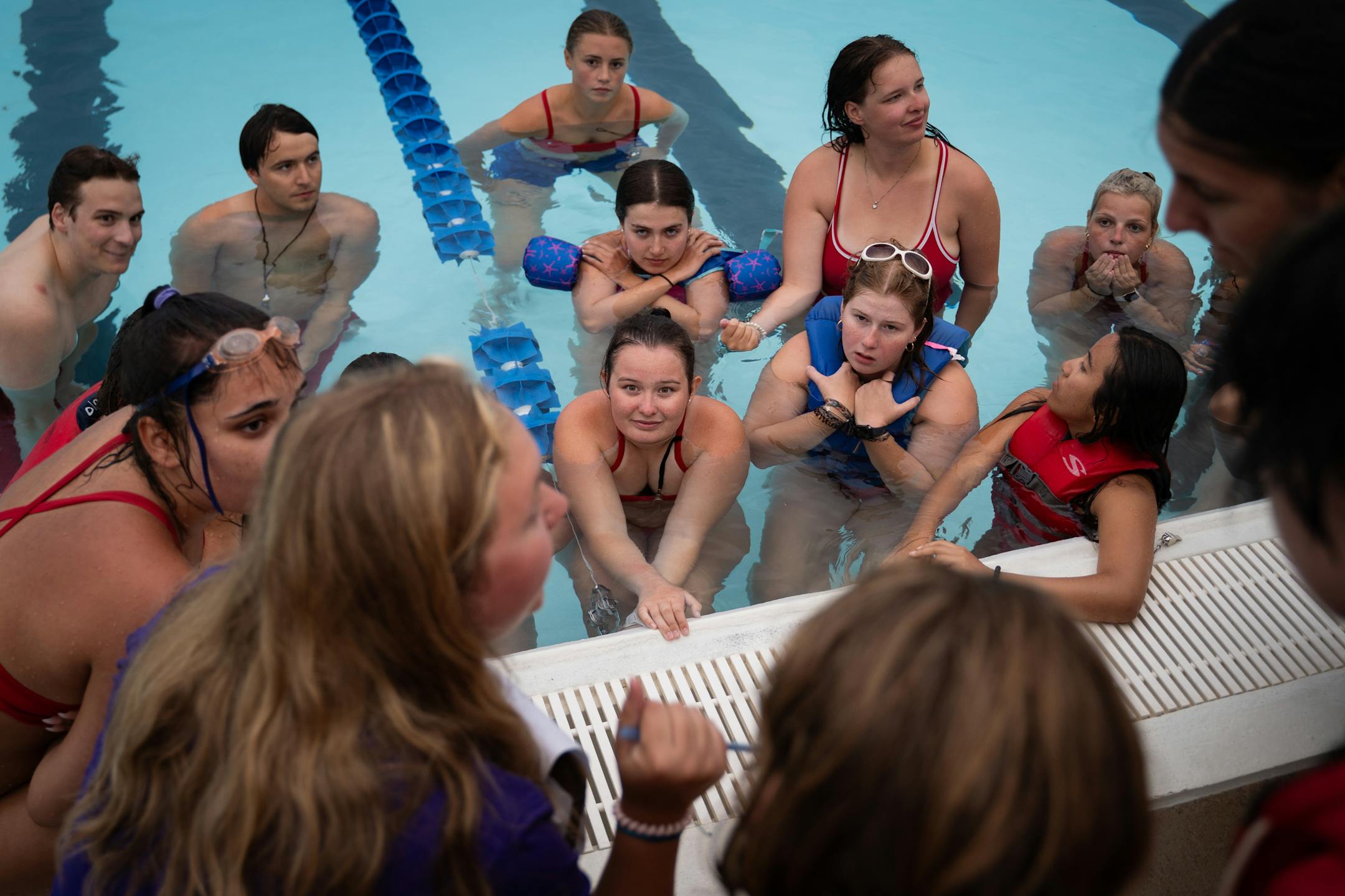 Lifeguards in training discuss the previous practice drill during lifeguard lessons at the Bloomington Family Aquatic Center in Bloomington, Minn. on Tuesday, July 11, 2023.