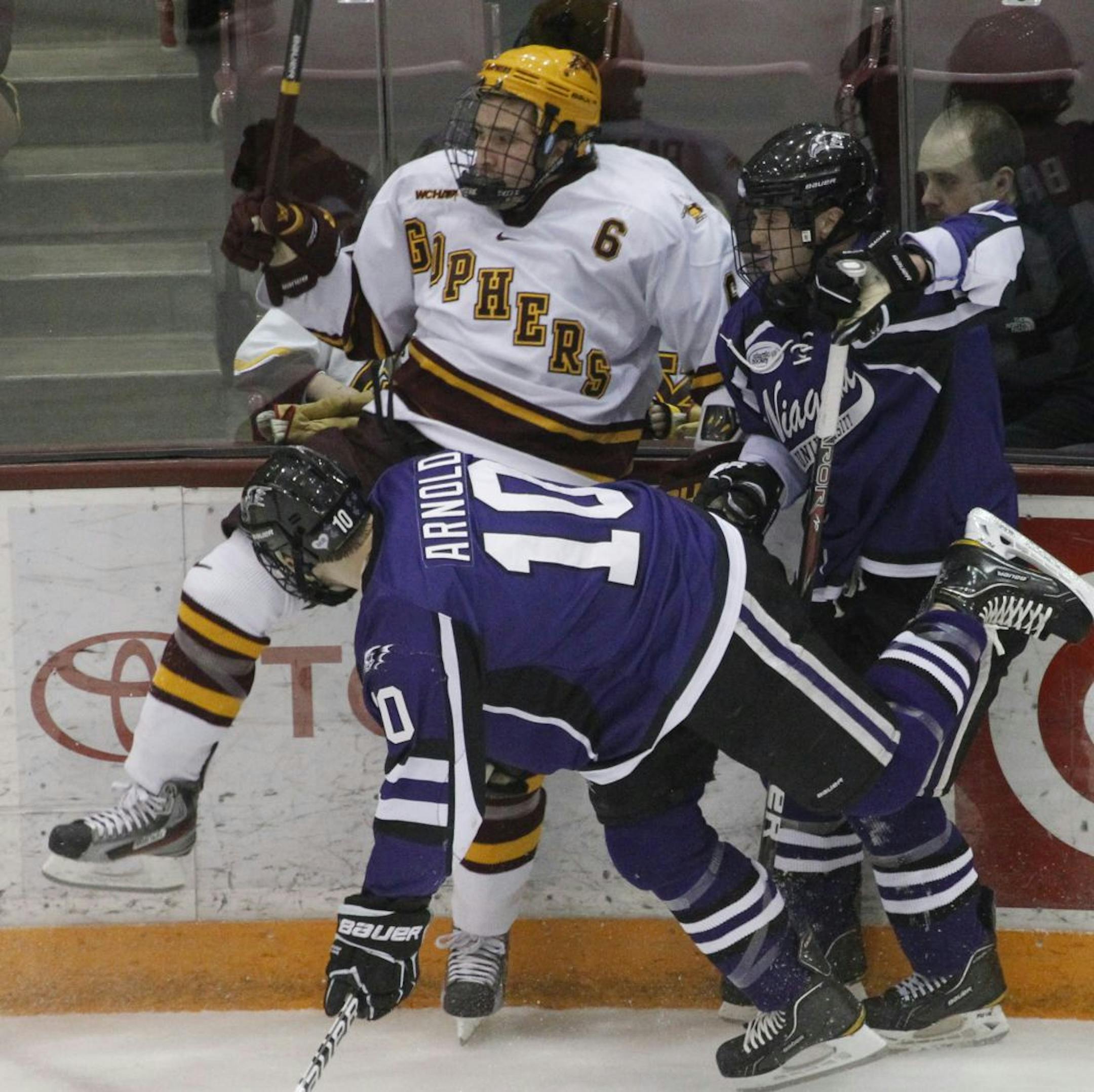 Gopher, Jake Parenteau, is checked into the boiards during first period action. Gophers men's hockey game vs. Niagara held at the University of Minnesota, Mariucci Arena Friday night. [ TOM WALLACE • twallace@startribune.com _ Assignments # 20020286C_ December 30, 2011_ SLUG: upuk1231_ EXTRA INFORMATION: Minnesota hosts the 21st annual Mariucci Classic this weekend, as it welcomes Niagara, Northeastern and Princeton to Mariucci Arena. The Gophers face Niagara tonight. Minnesota is 2-0-0 all-time