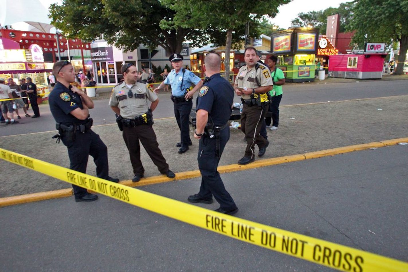 Police adjust crime scene tape at the intersection of Dan Patch Ave and Cooper St. on the state fair grounds in Falcon Heights where a knife stabbing incident occurred Sunday evening. (MARLIN LEVISON/STARTRIBUNE(mlevison@startribune.com