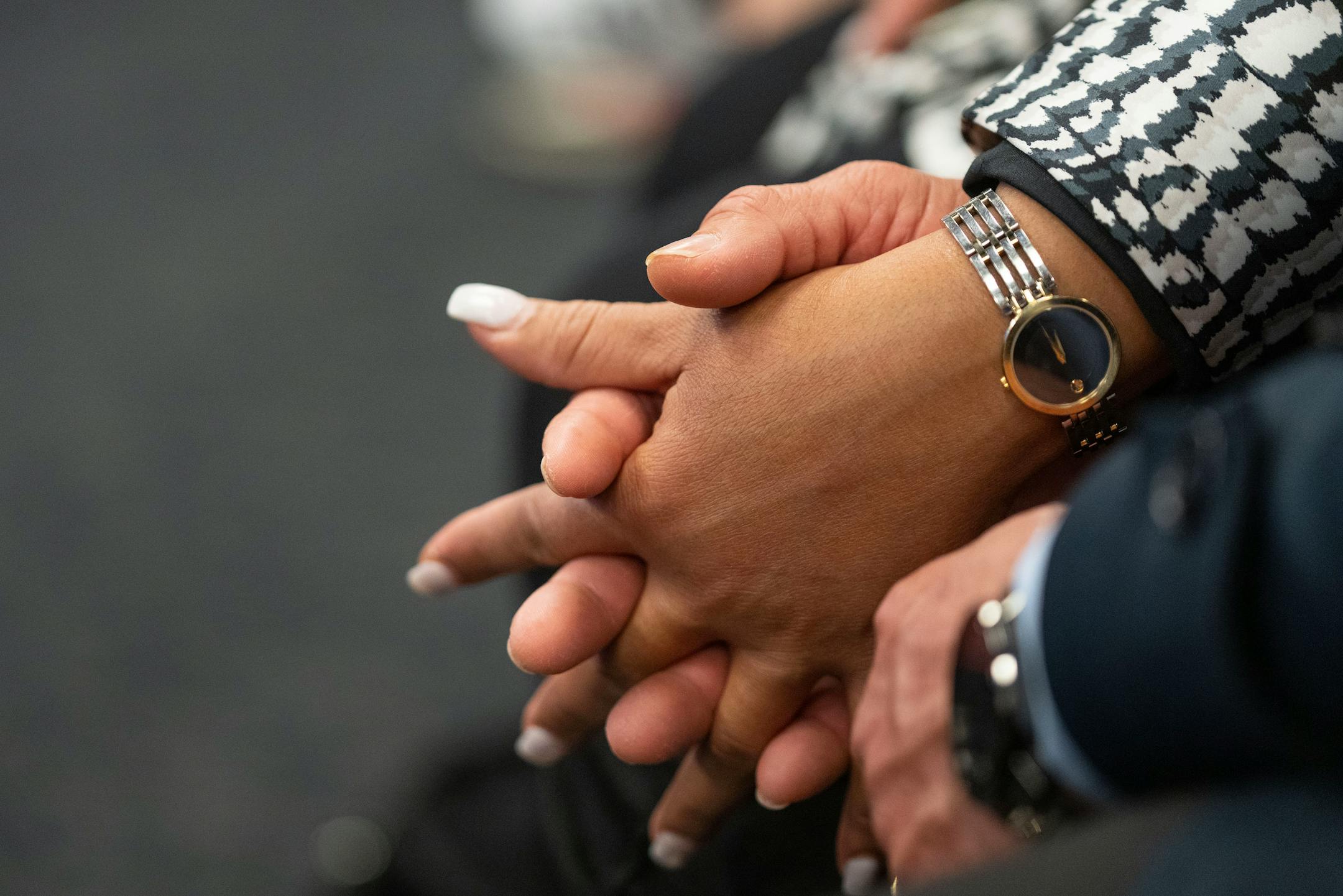 Carlos Correa Sr. and Sandybel Oppenheimer, Carlos Correa's parents, hold hands during a press conference.